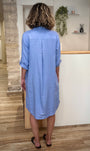 Silhouette féminine en robe fluide bleu pastel de dos