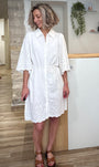Femme portant une robe chemise blanche en coton avec broderie anglaise 