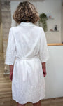 Femme de dos portant une robe brodée blanche en coton naturel 
