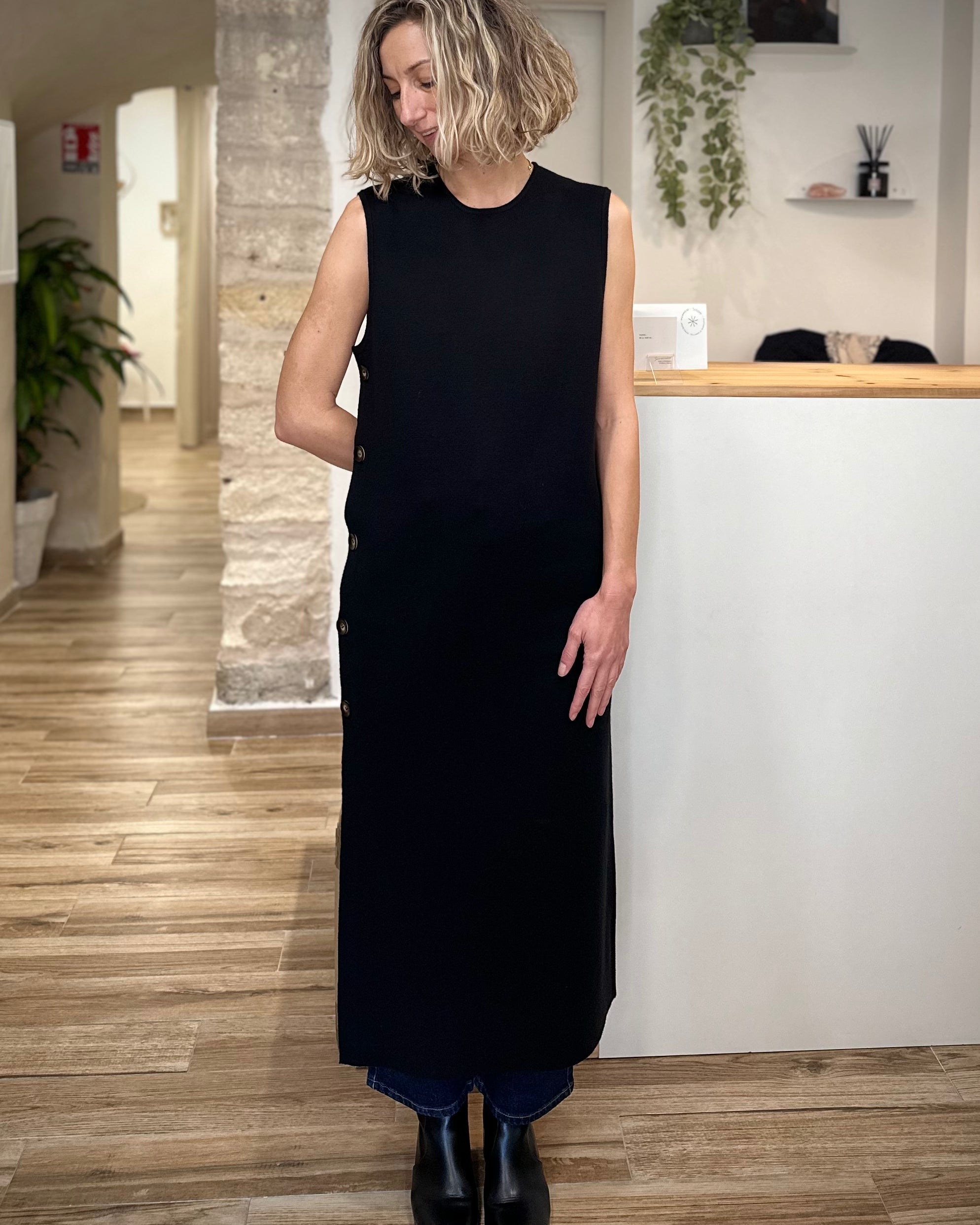 Femme portant une robe longue noire droite avec boutons latéraux