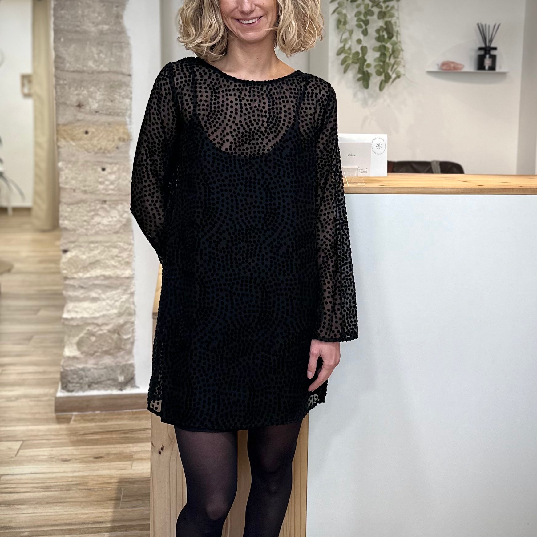 Femme portant robe plumetis noire Riska, coupe droite