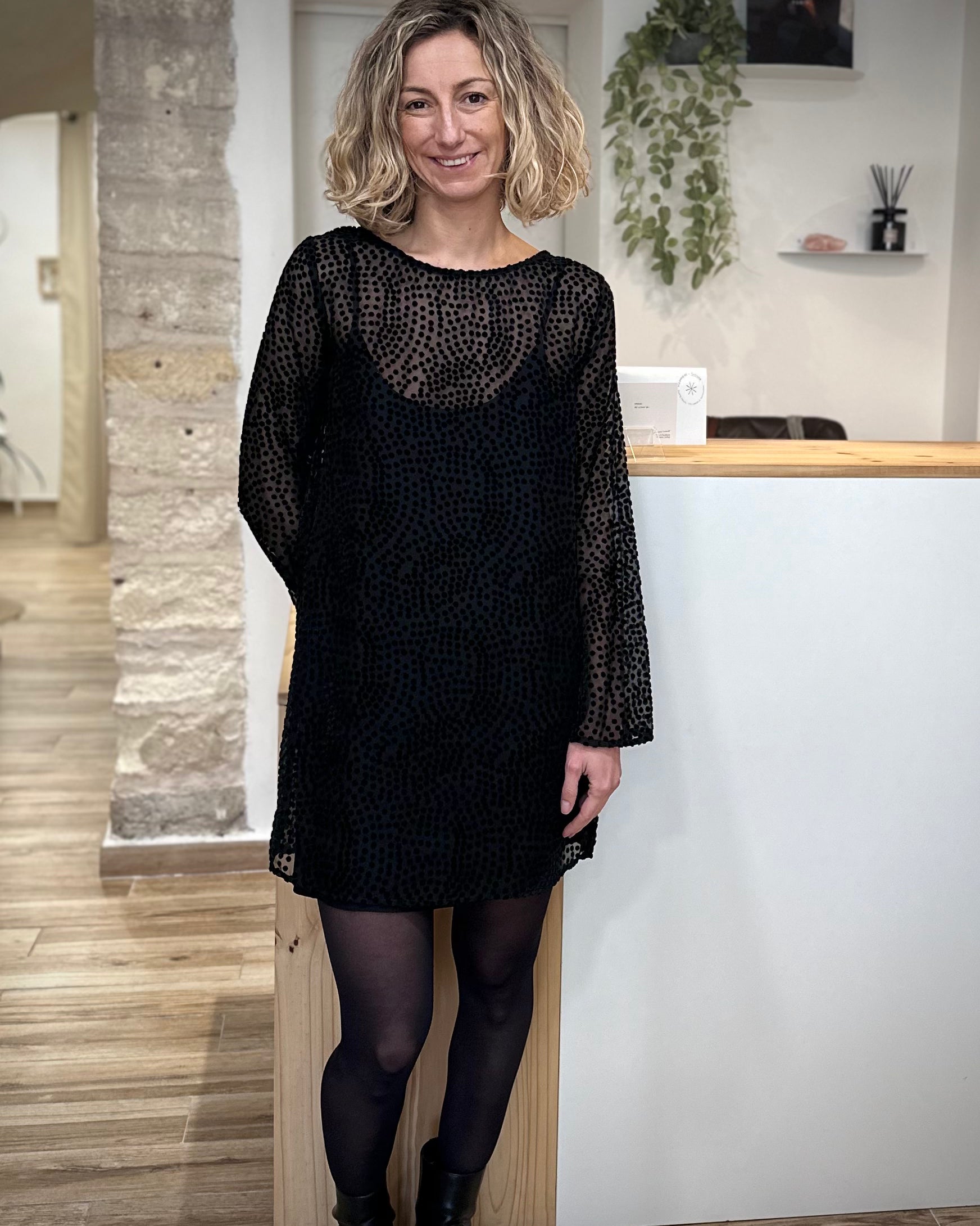 Femme portant robe plumetis noire Riska, coupe droite