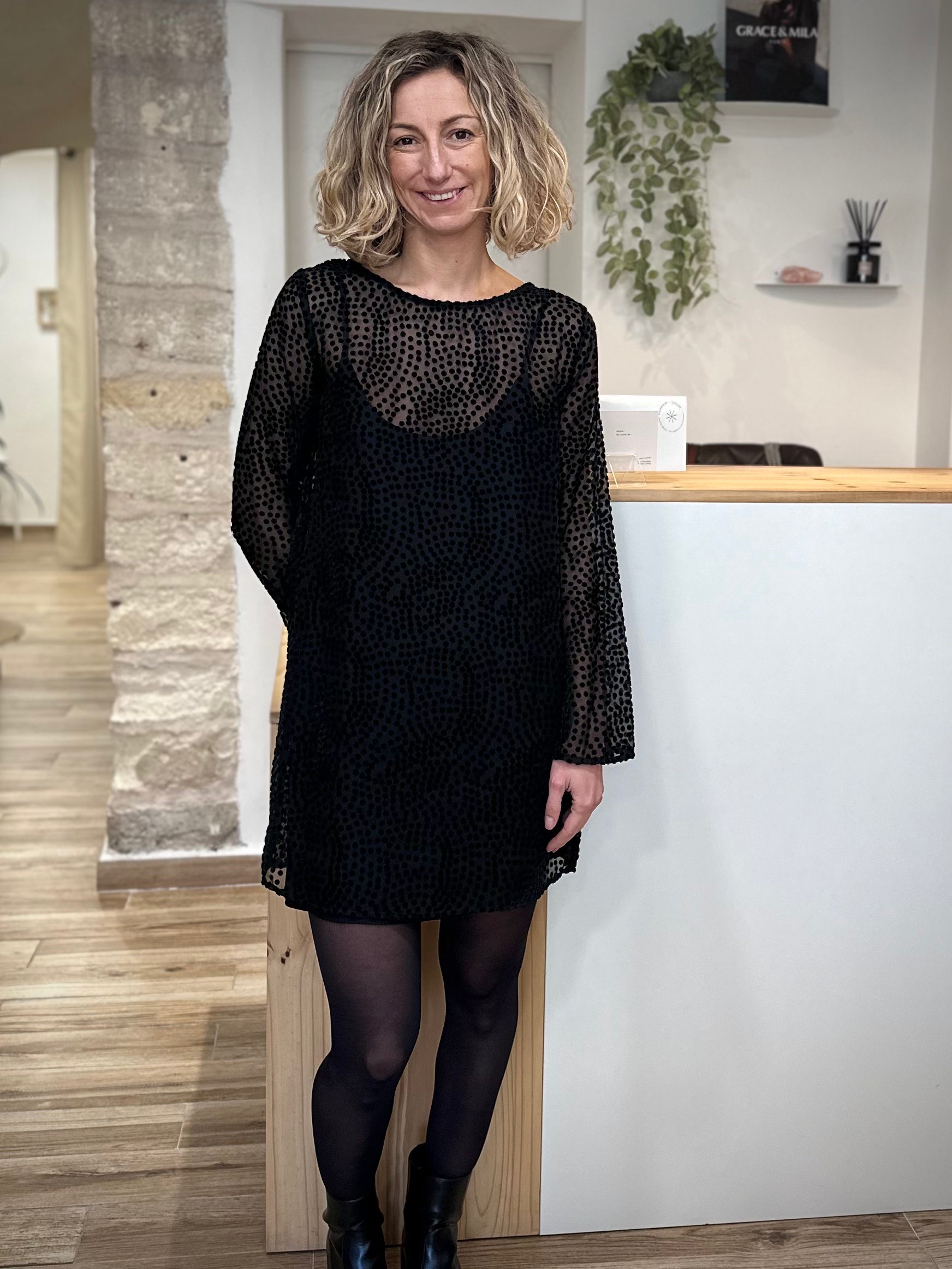 Femme portant robe plumetis noire Riska, coupe droite