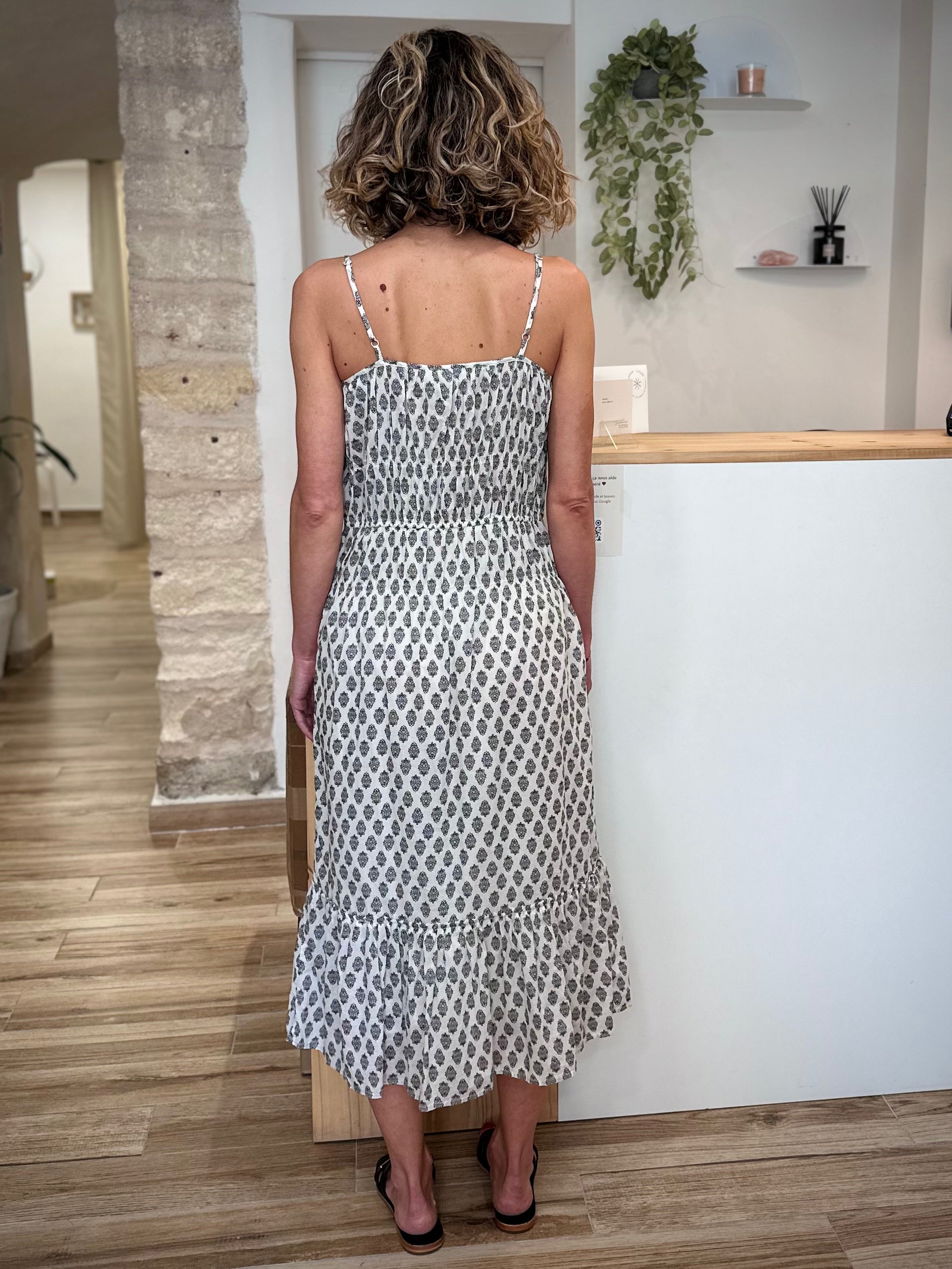 Femme de dos portant une robe longue en coton sans manches 