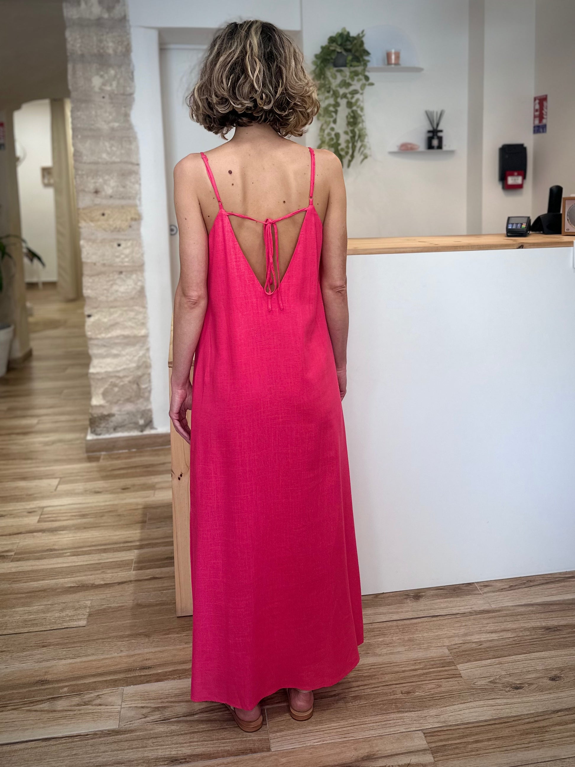 Silhouette féminine de dos avec robe longue fuchsia 