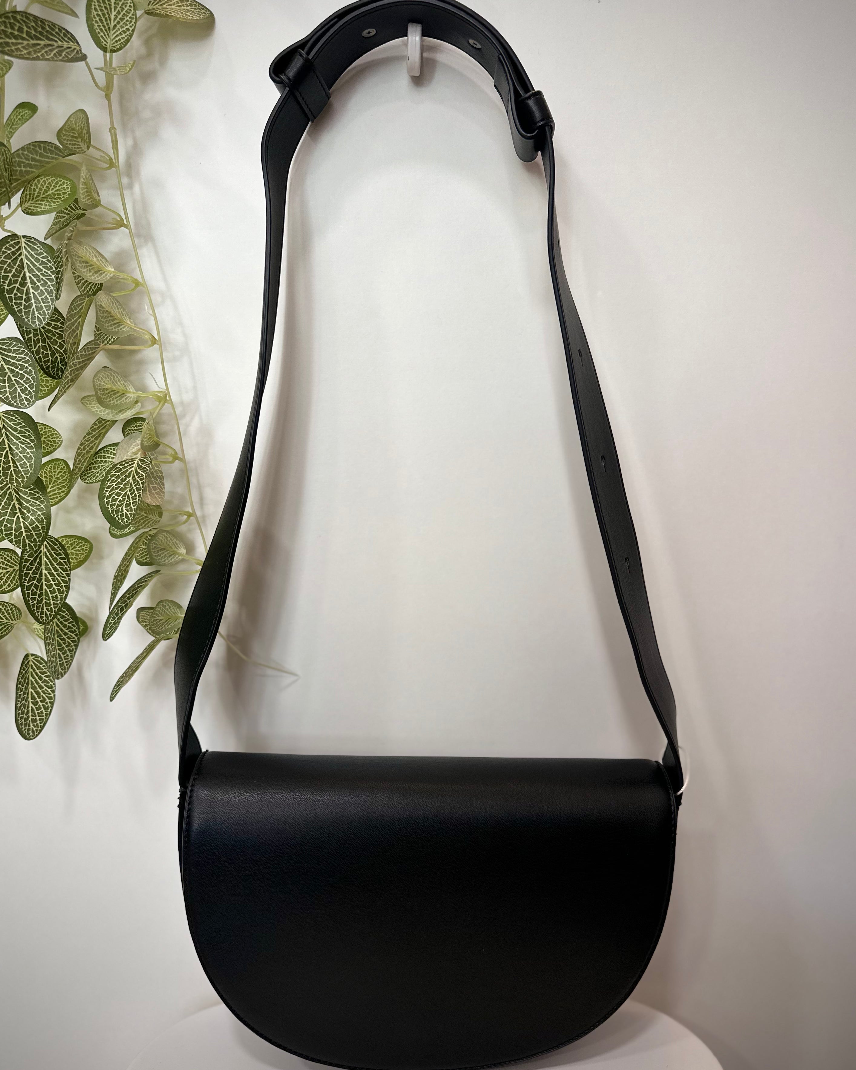 Sac CLIFF noir posé sur un tabouret en bois clair