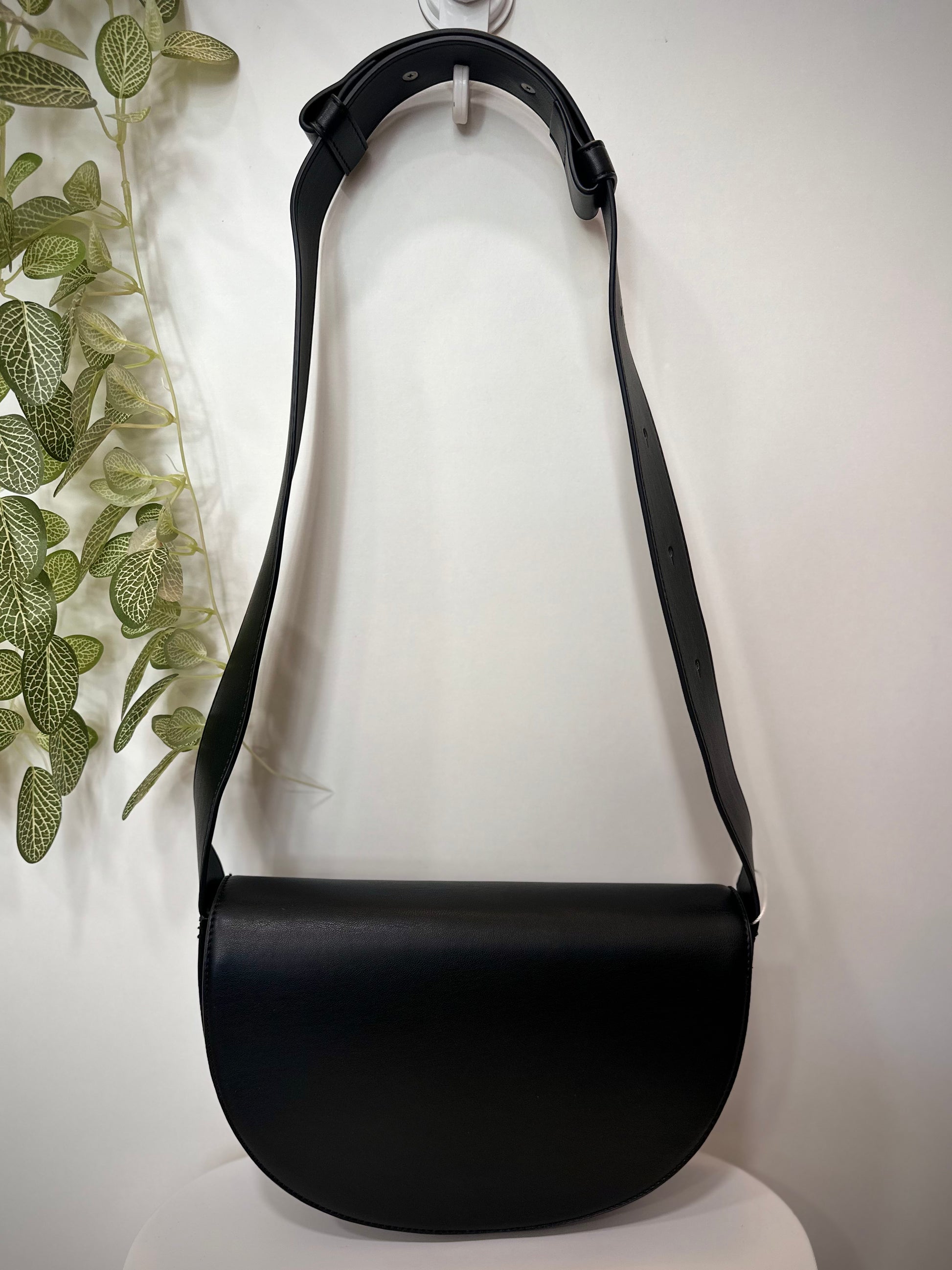 Sac CLIFF noir posé sur un tabouret en bois clair