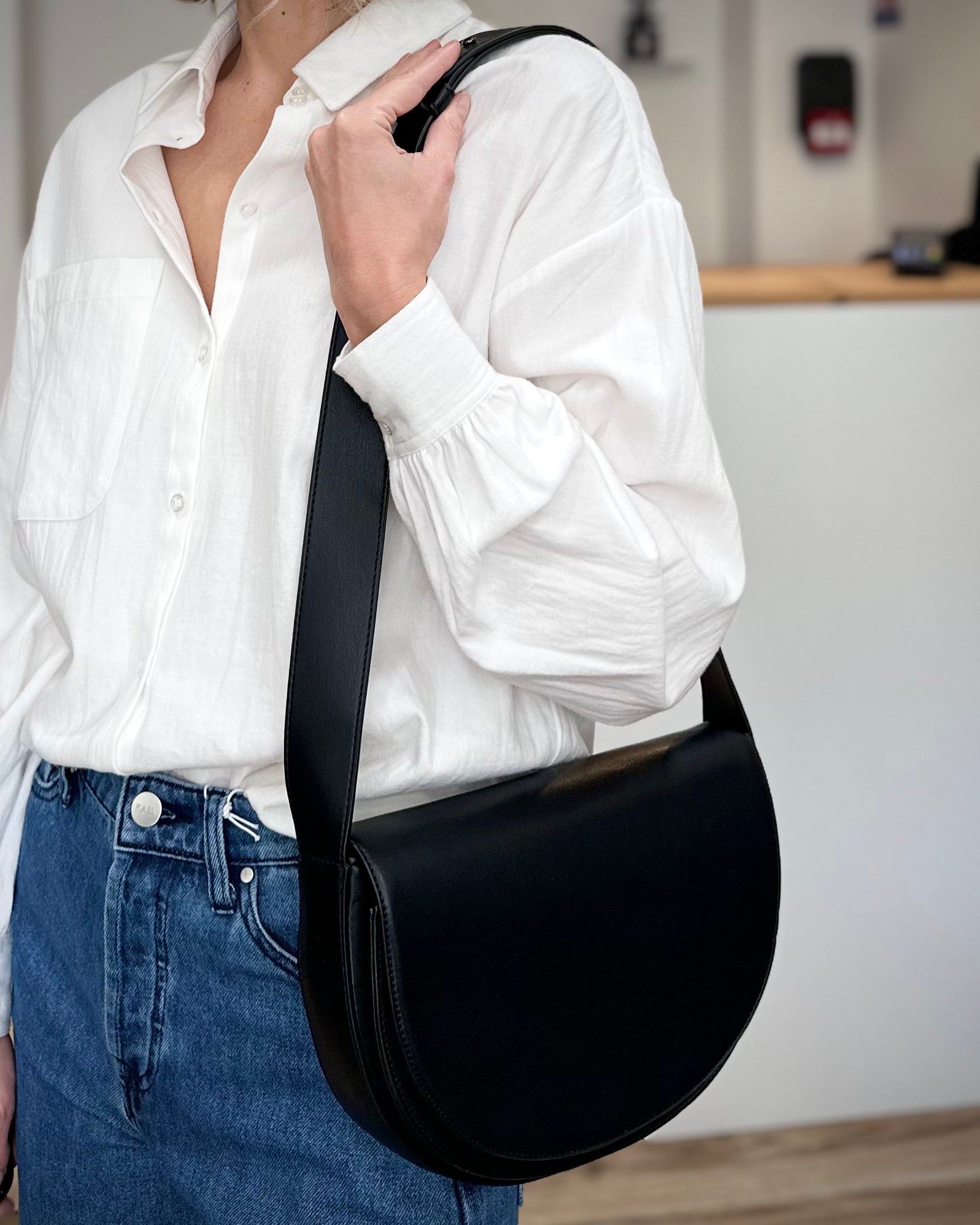 Femme portant un sac épaule demi-lune noir HVISK