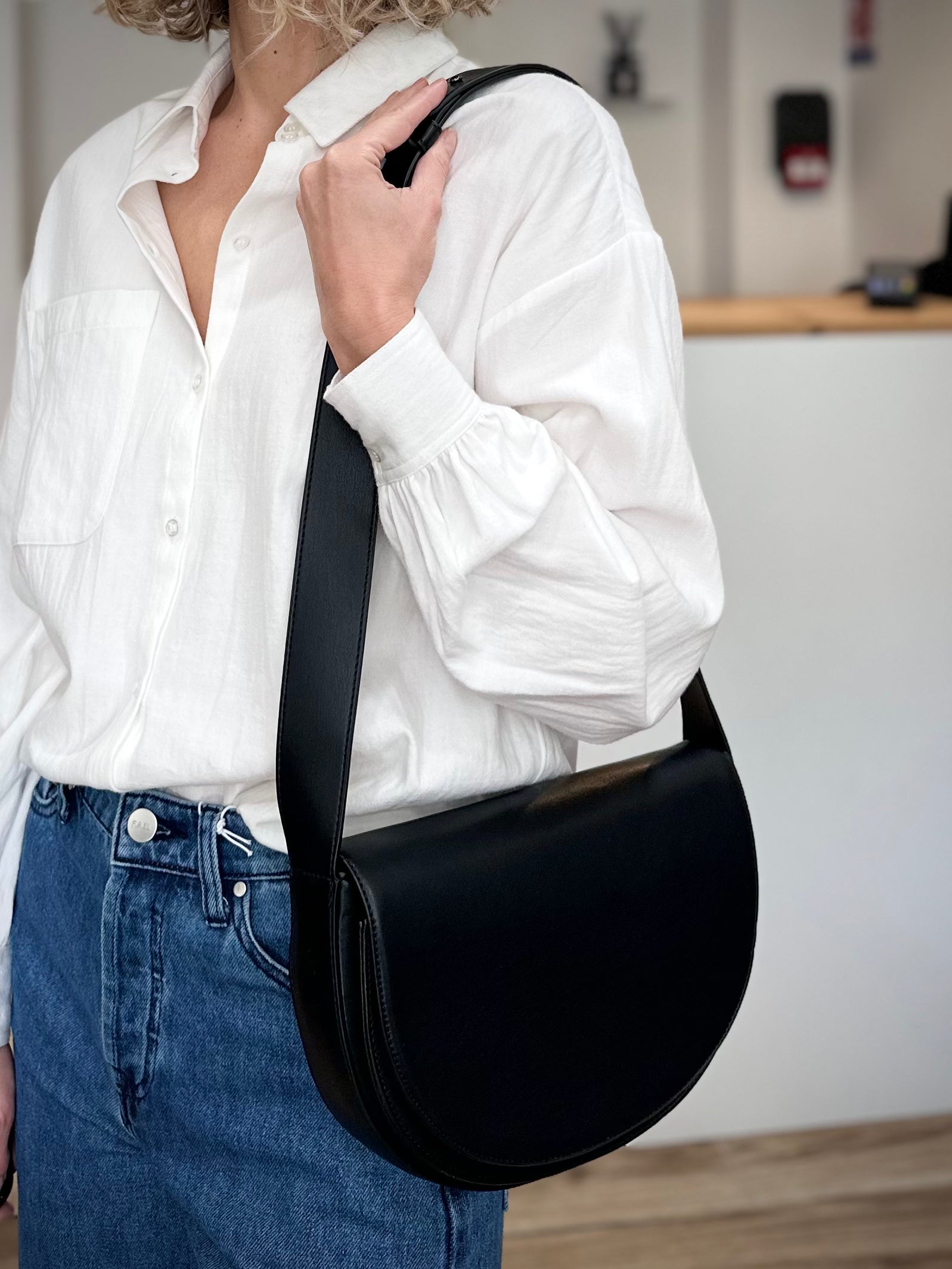 Femme portant un sac épaule demi-lune noir HVISK