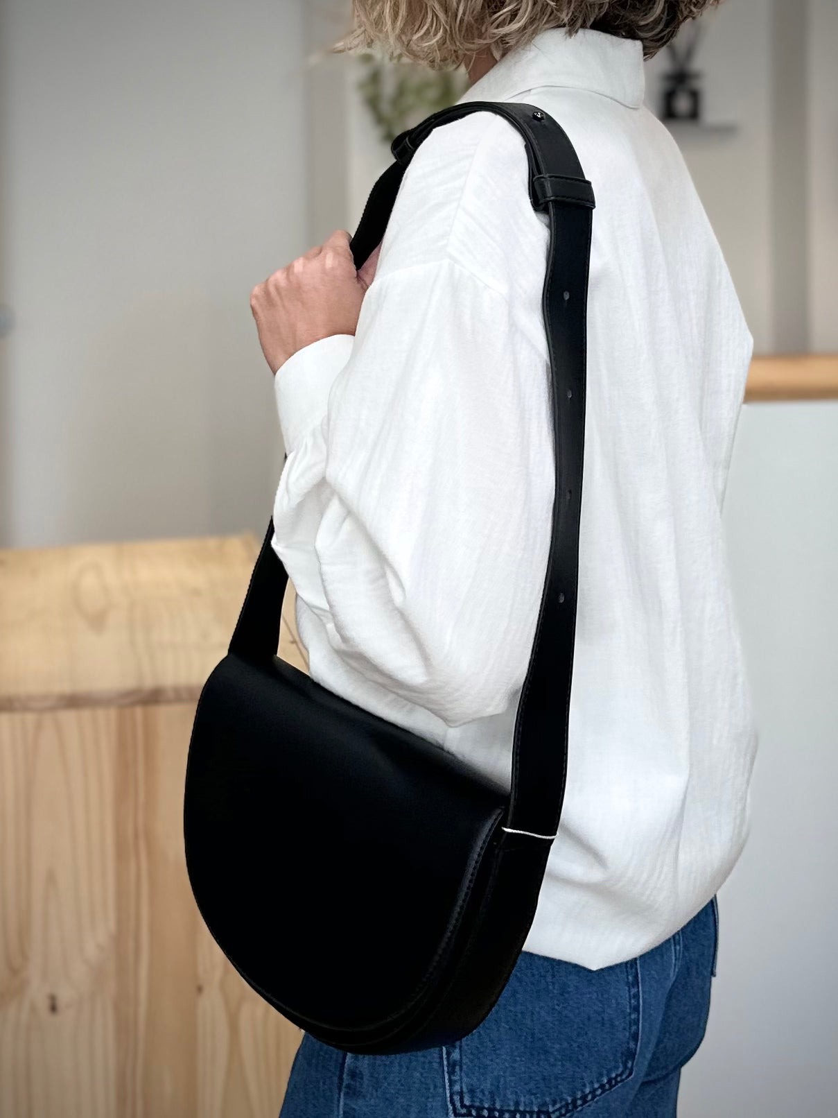 Femme en tenue casual chic avec sac noir à l’épaule