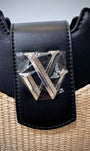 Détail logo argenté sur sac noir 