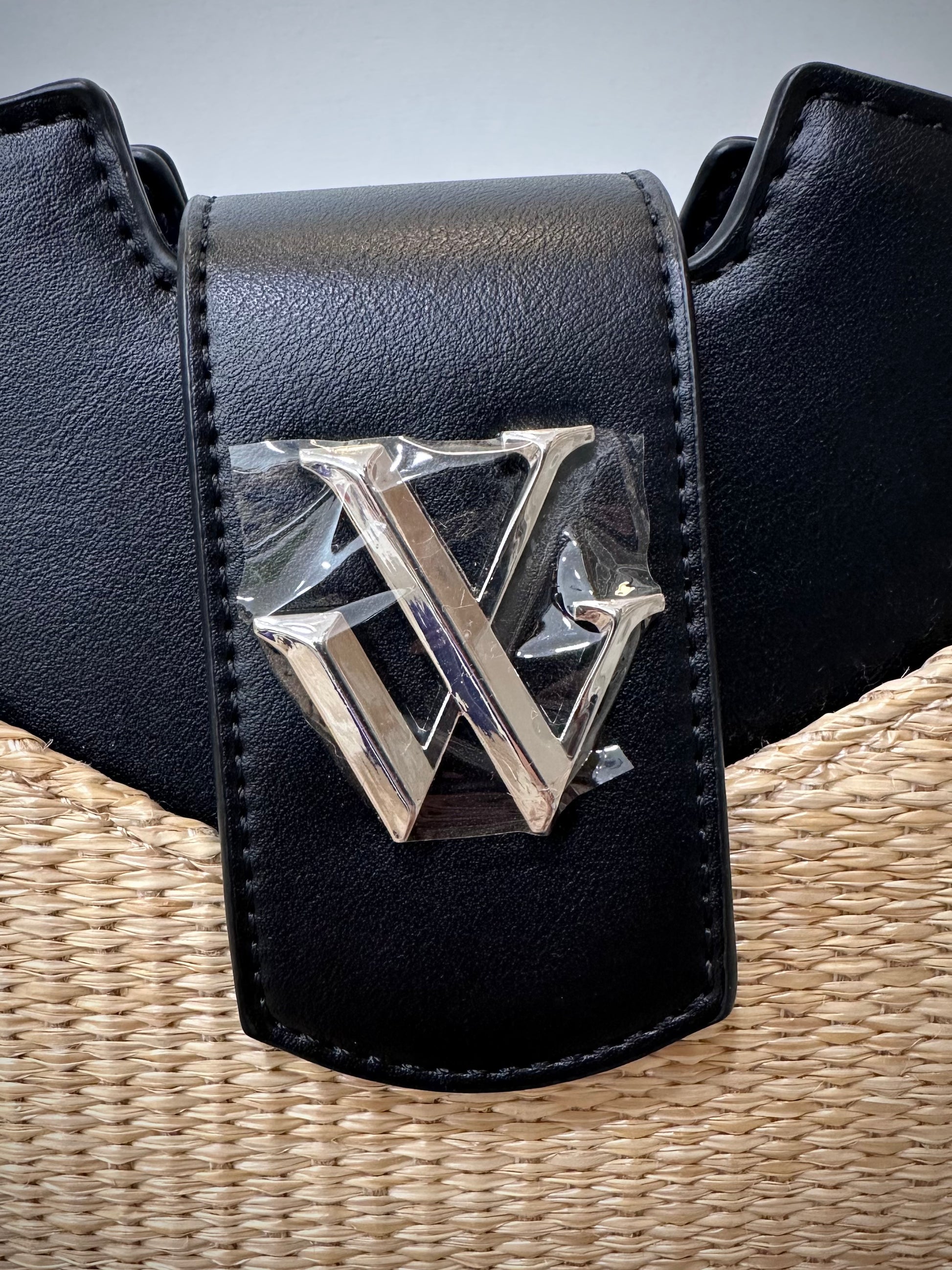 Détail logo argenté sur sac noir 