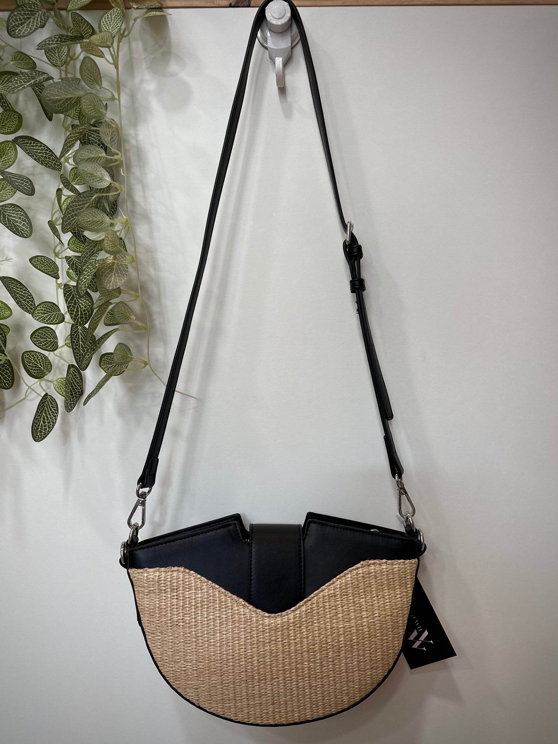 Sac demi-lune noir suspendu fond clair vue arrière