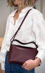 Femme en tenue casual chic avec sac cuir vegan bordeaux