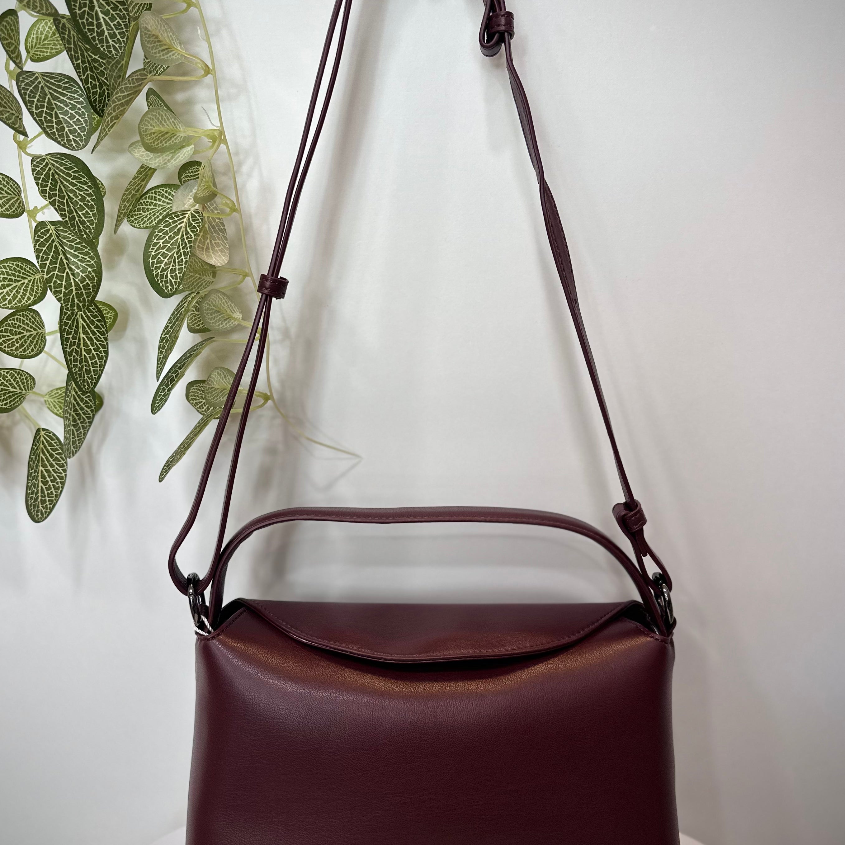 Sac NOTE bordeaux posé sur un tabouret en bois clair