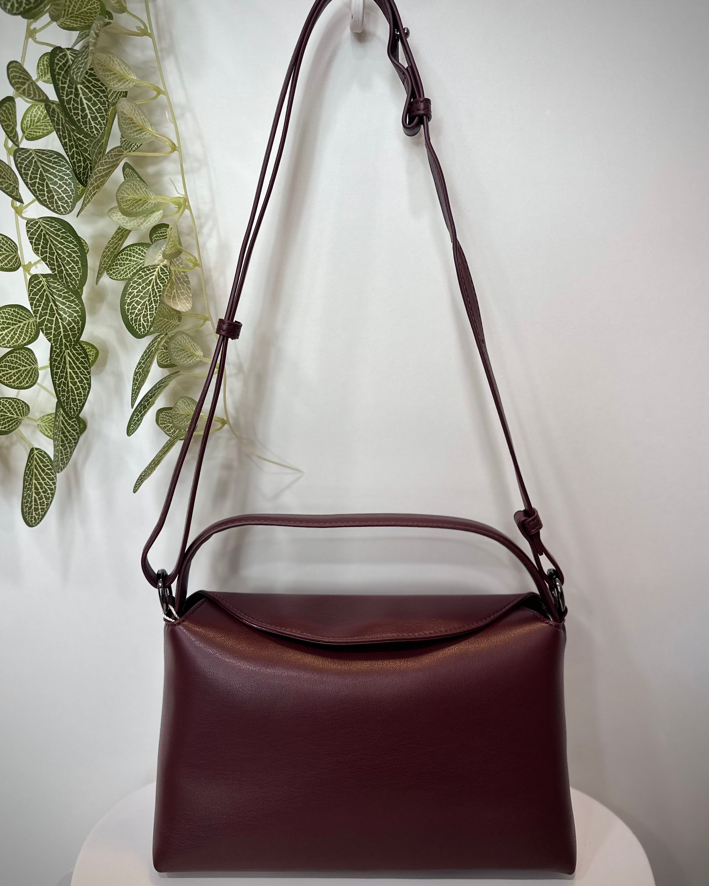 Sac NOTE bordeaux posé sur un tabouret en bois clair