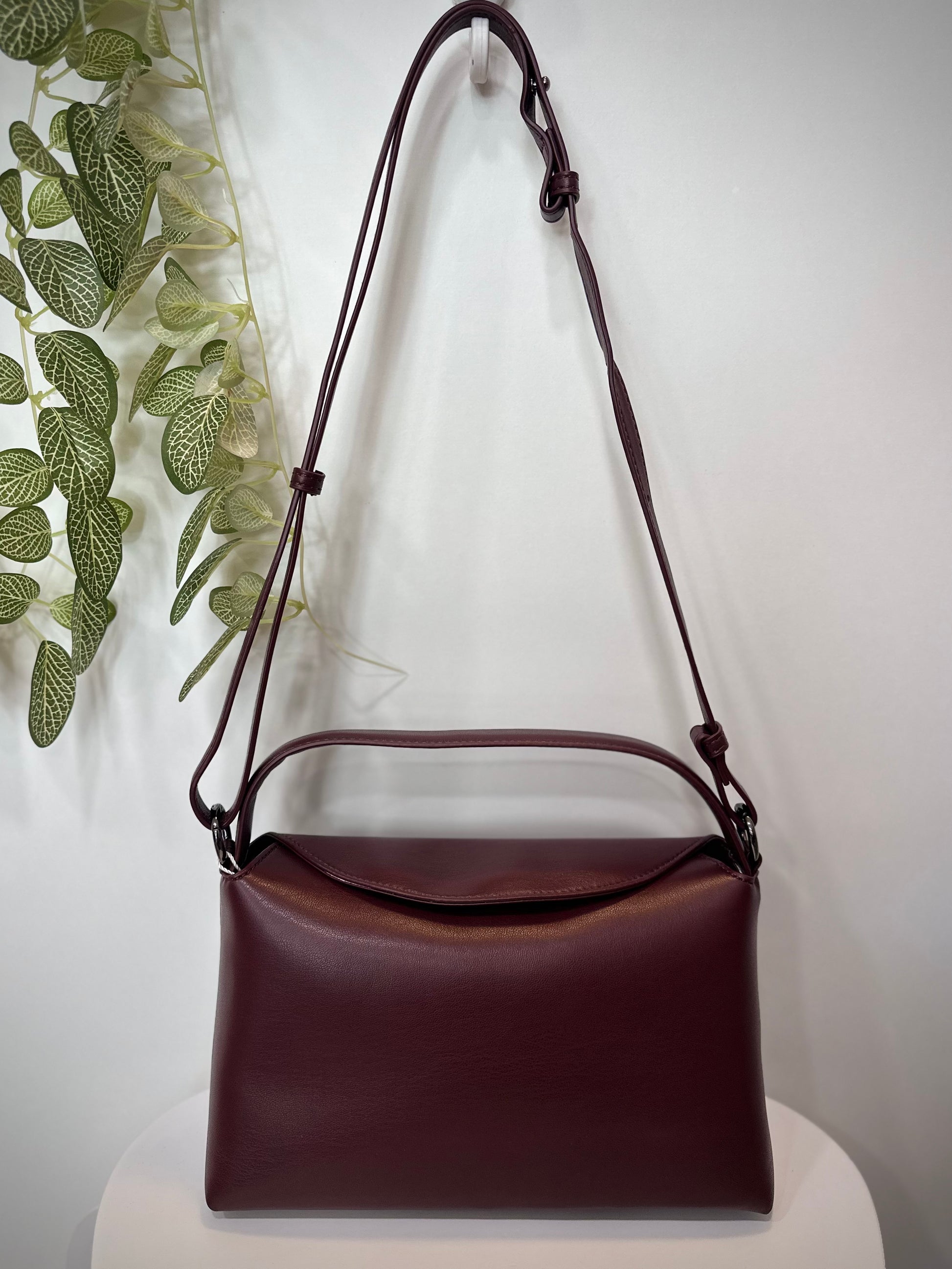 Sac NOTE bordeaux posé sur un tabouret en bois clair