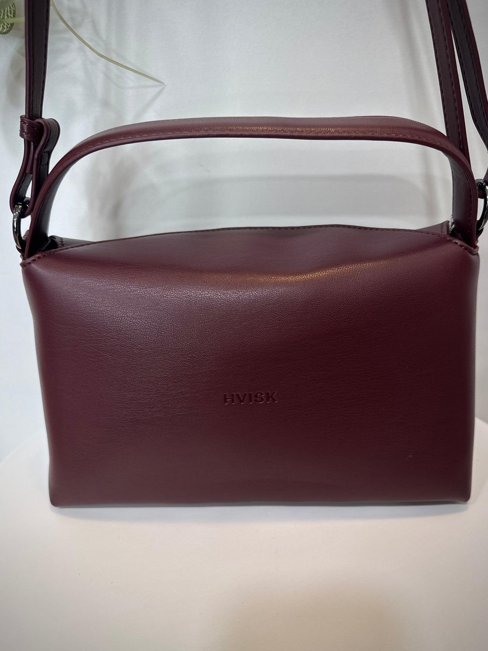 Vue arrière du sac à main structuré bordeaux sur fond lumineux