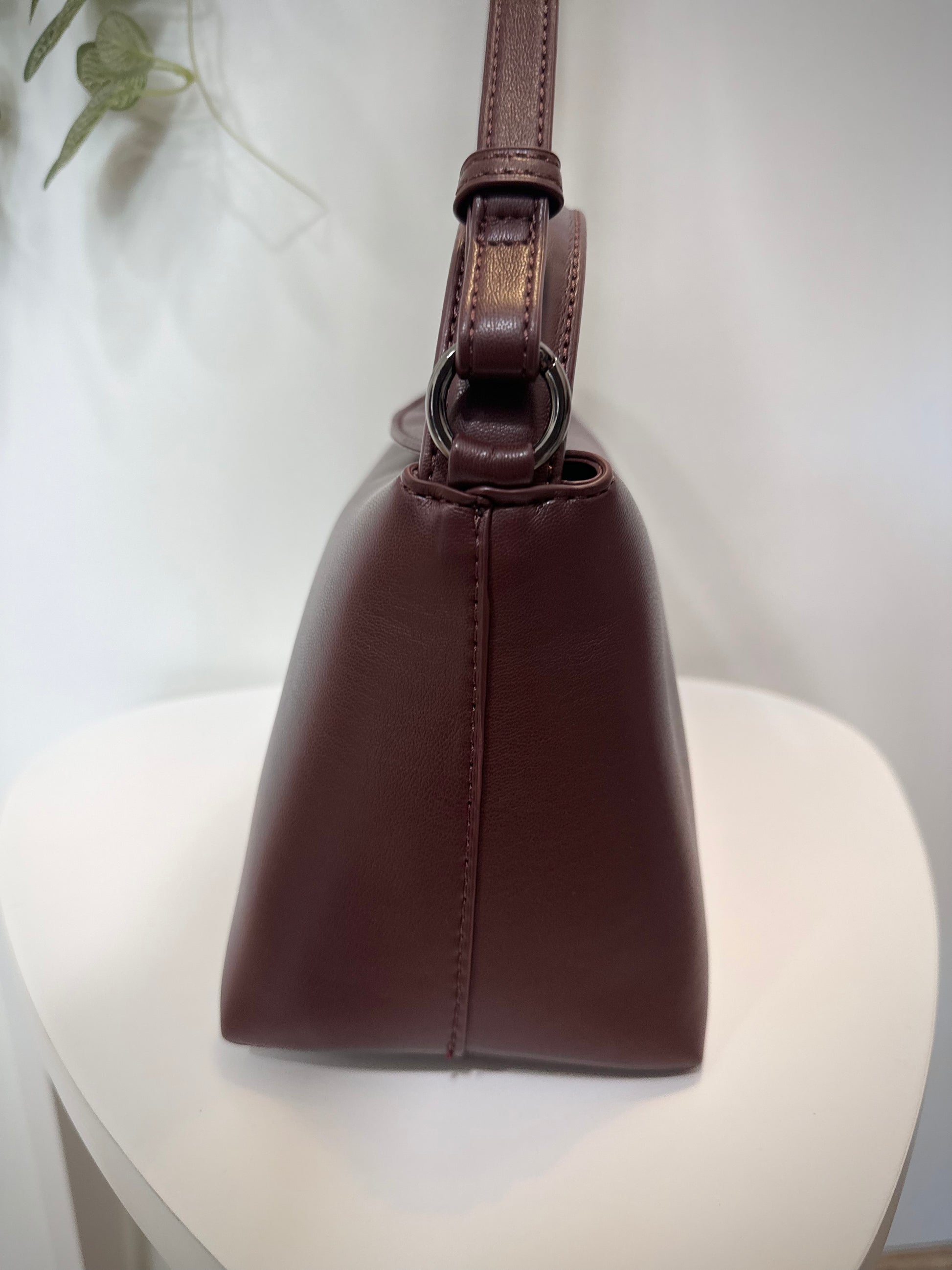 Vue latérale du sac à main élégant bordeaux