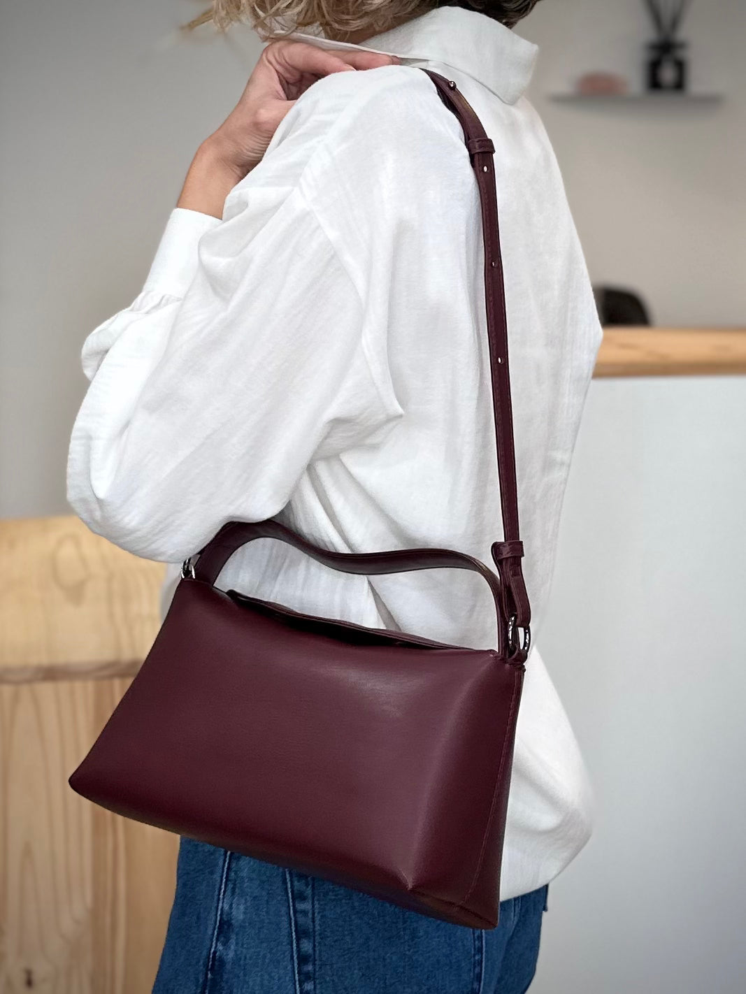 Femme portant un sac à main vegan bordeaux à l’épaule