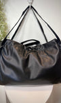 Sac SAGE noir posé sur un tabouret en bois clair