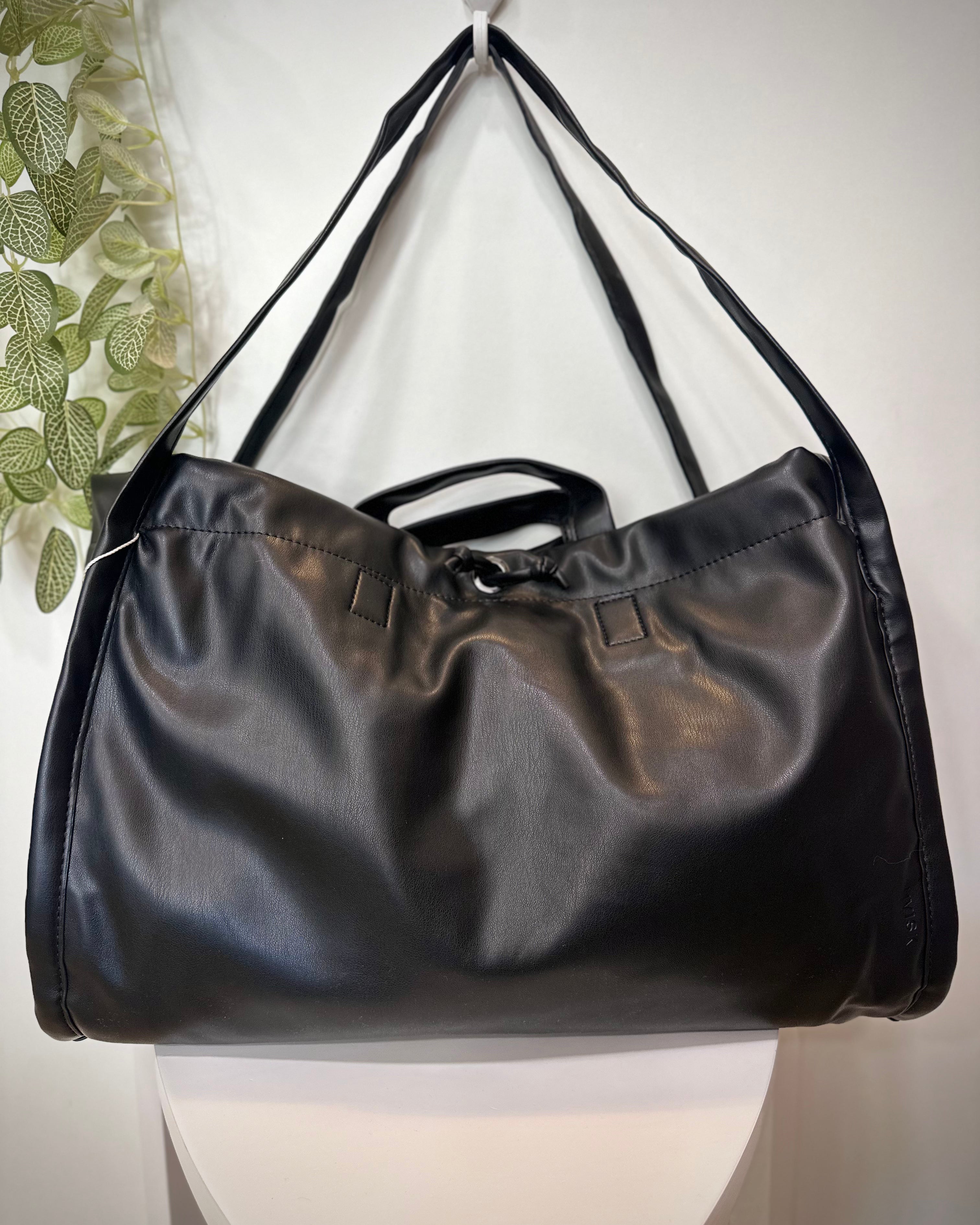 Sac SAGE noir posé sur un tabouret en bois clair