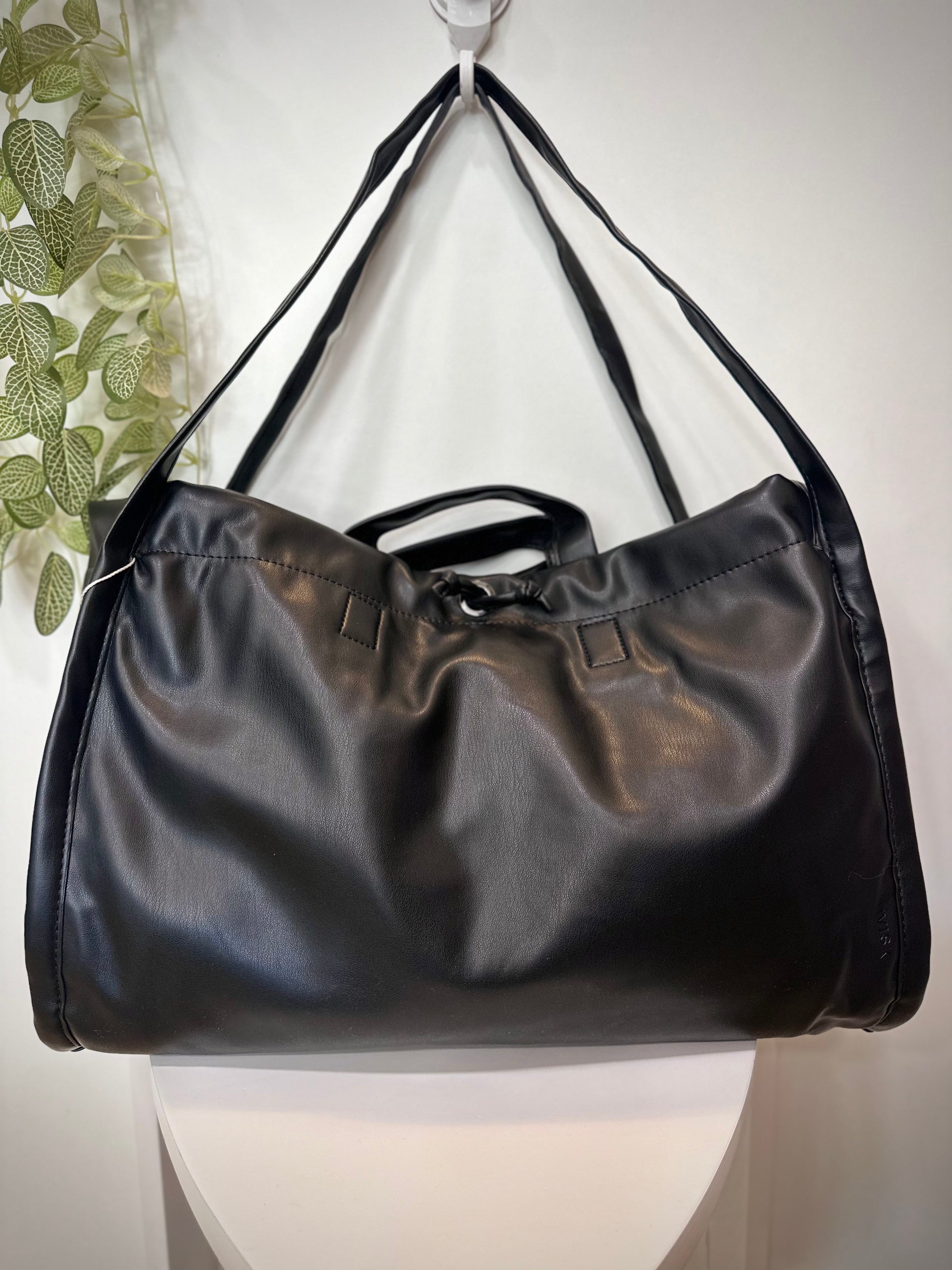 Sac SAGE noir posé sur un tabouret en bois clair