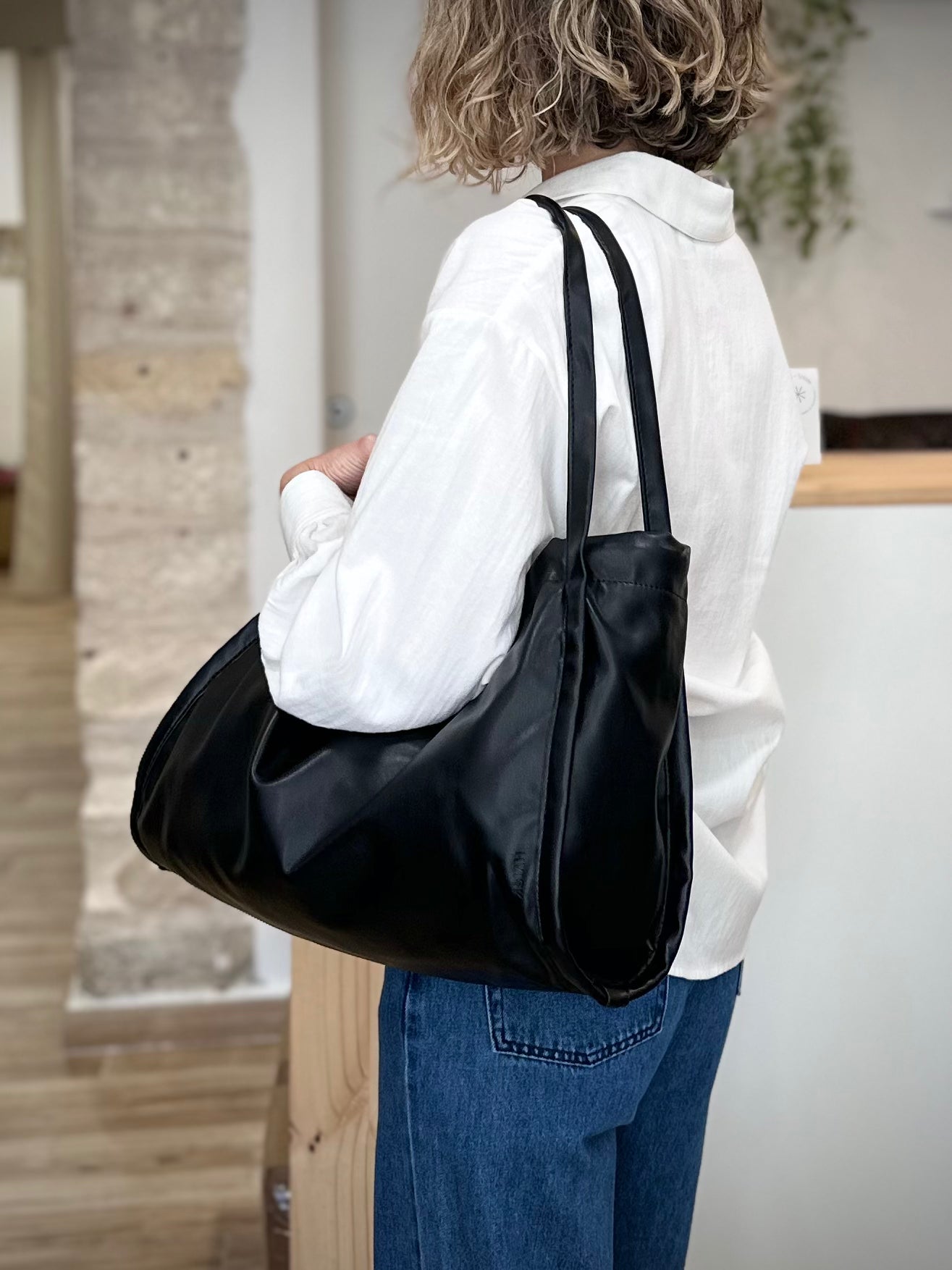 Femme portant un sac shopper vegan noir HVISK à l’épaule