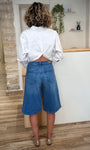 Femme de dos portant un bermuda jean large 
