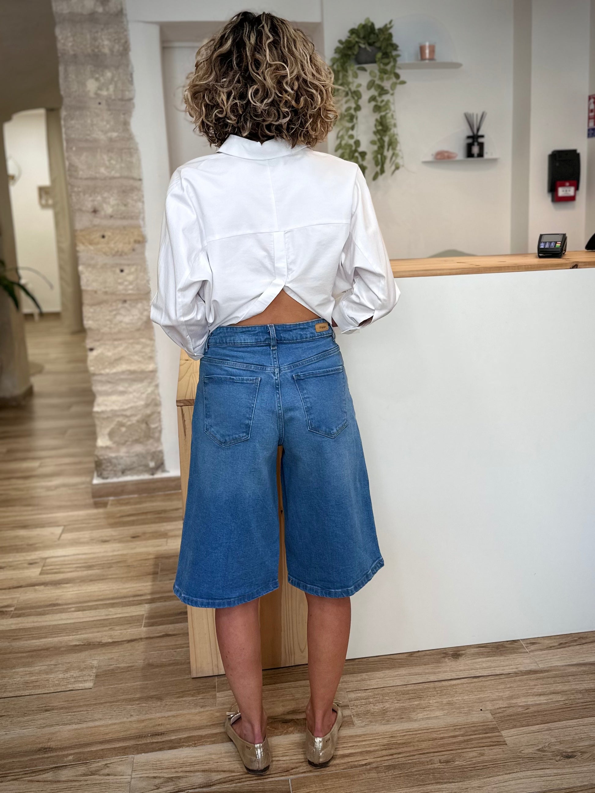 Femme de dos portant un bermuda jean large 