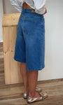 Femme de profil portant short large taille haute denim 