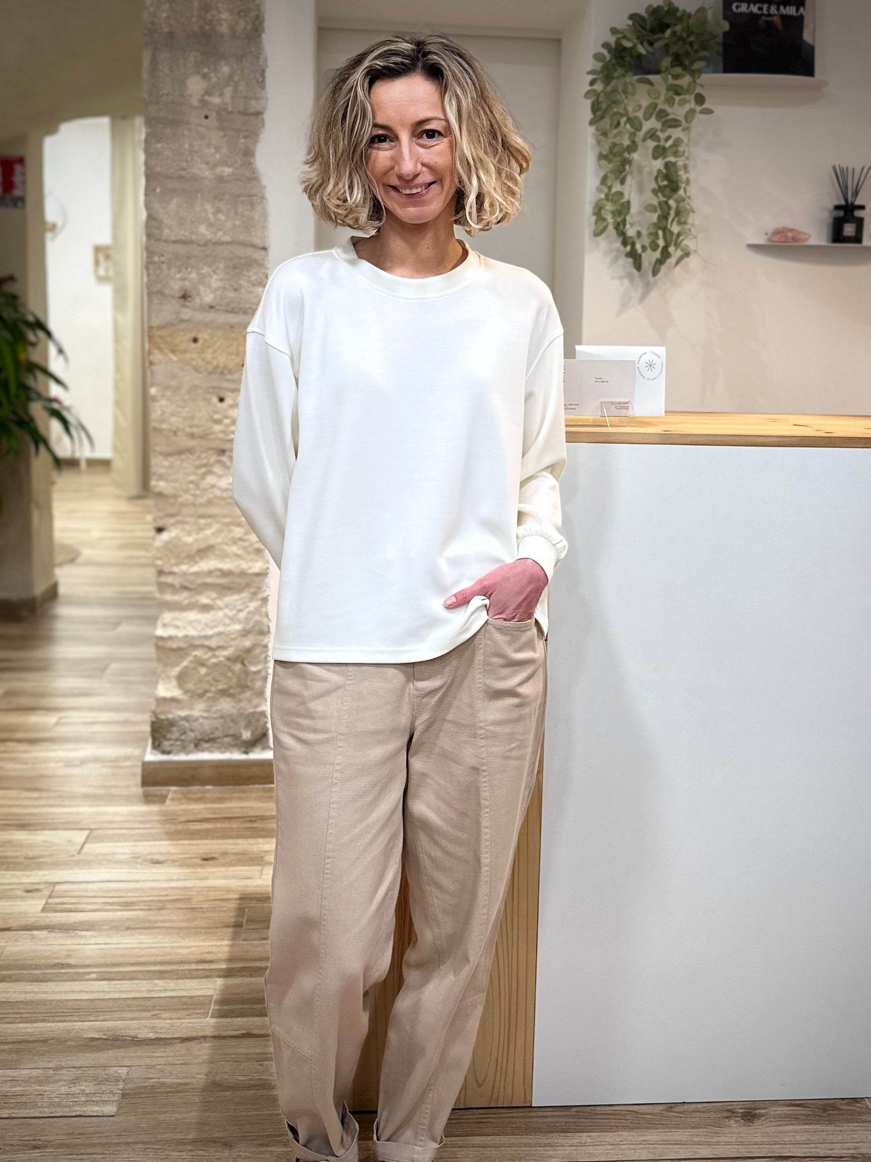 Sweat blanc minimaliste porté avec pantalon clair