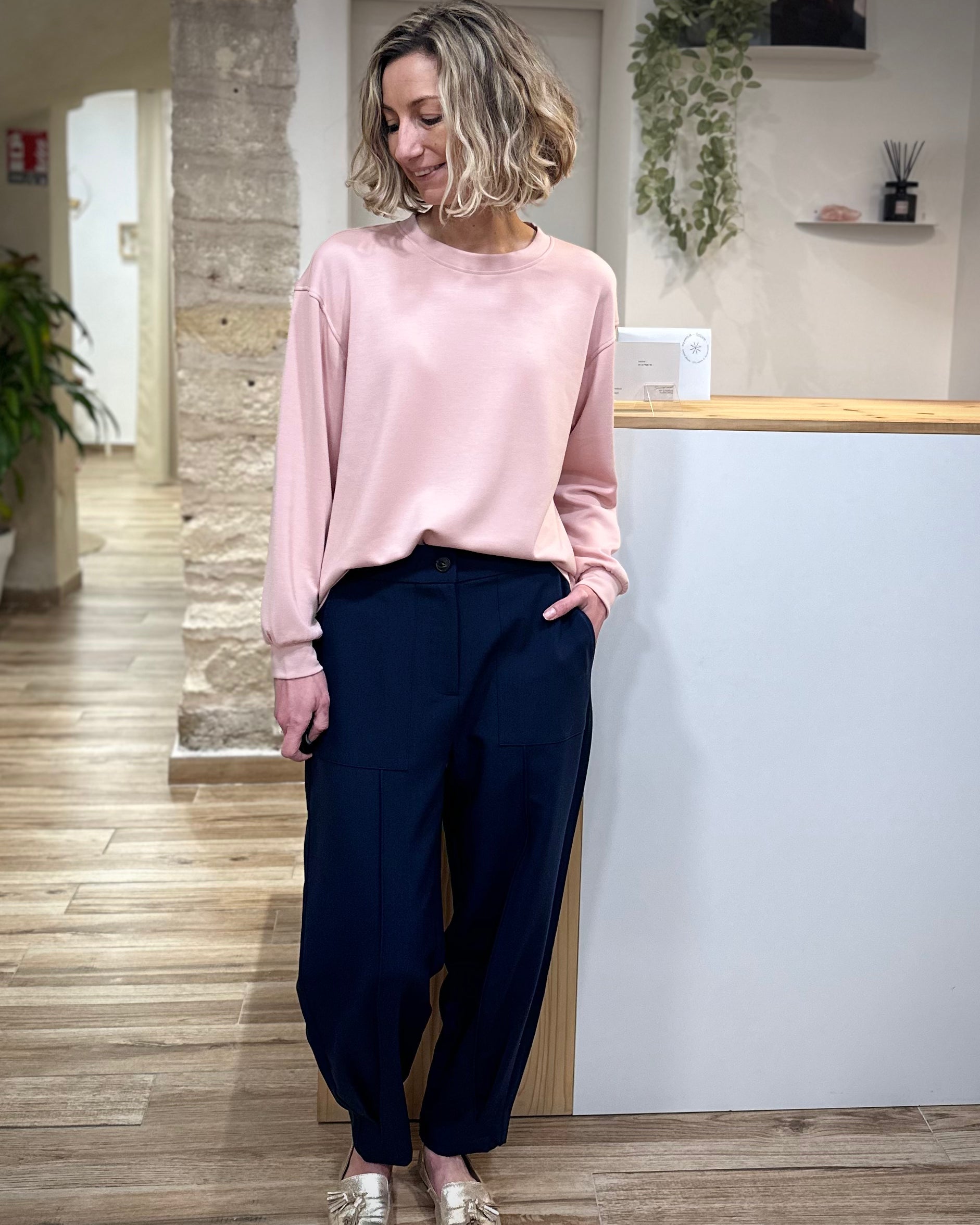 Femme portant un sweat rose pâle coupe loose