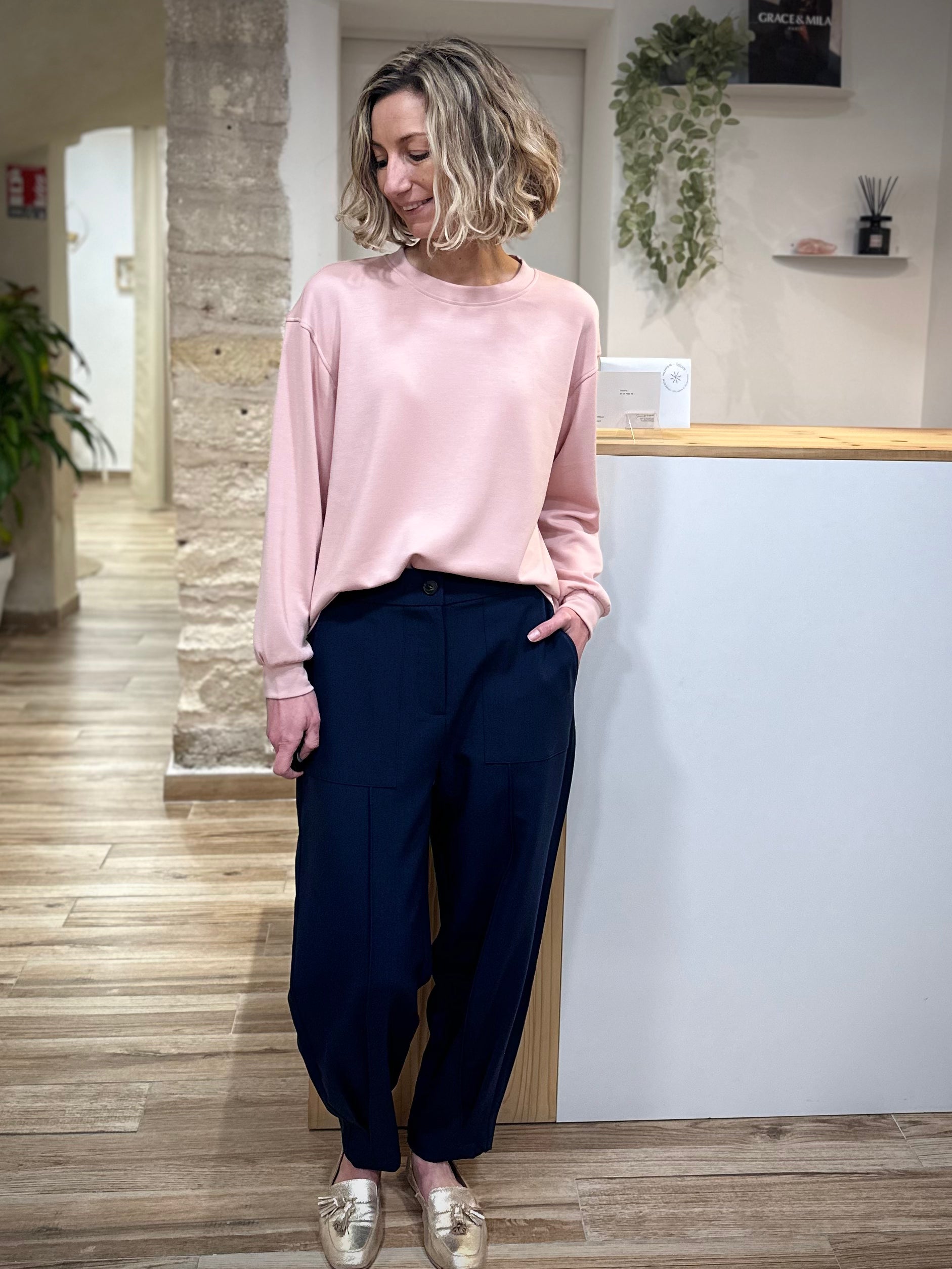 Femme portant un sweat rose pâle coupe loose