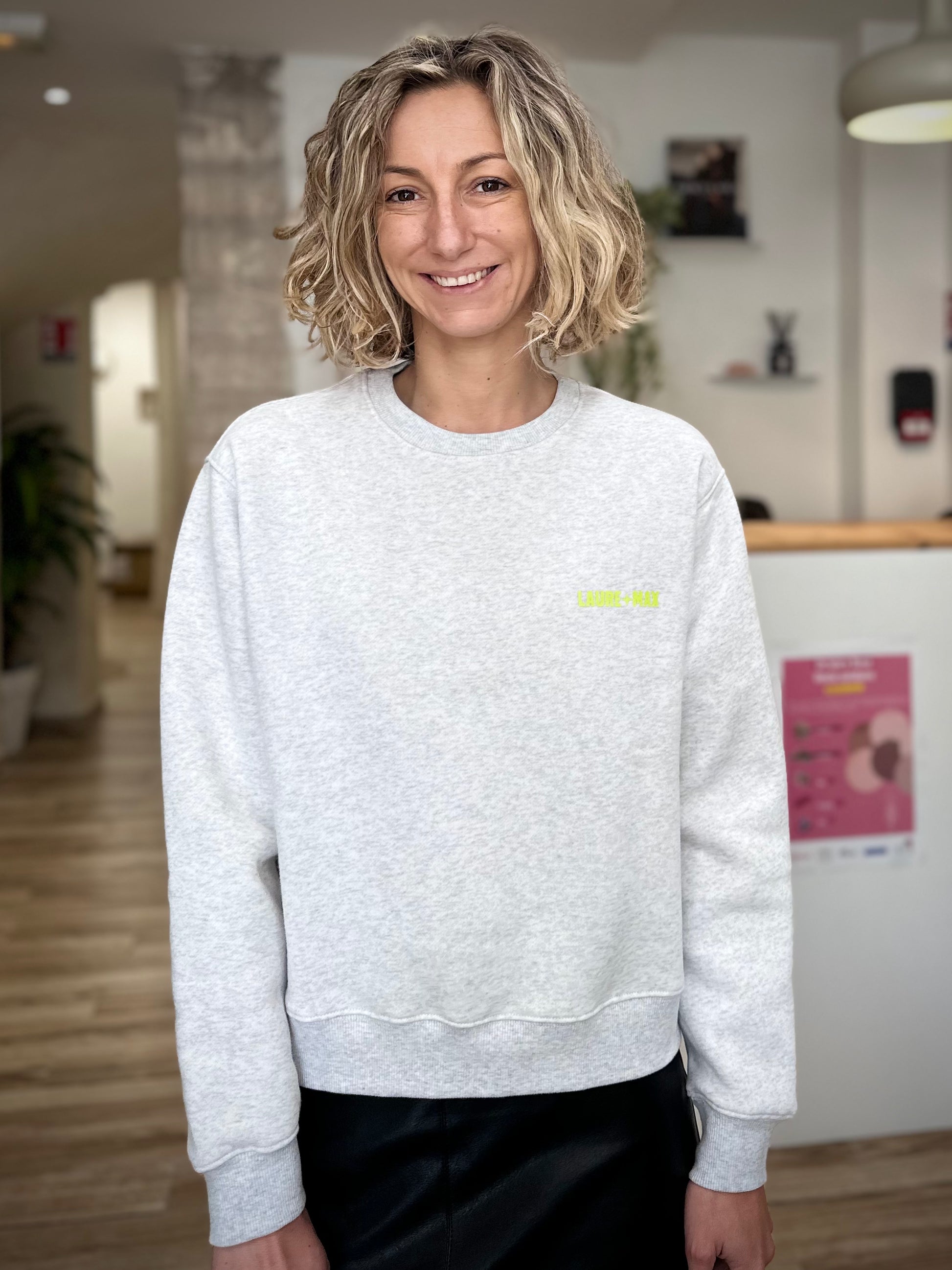 Femme souriante portant sweat gris casual chic