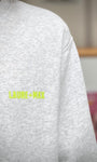 Gros plan sur logo fluo LAURE+MAX sur sweat