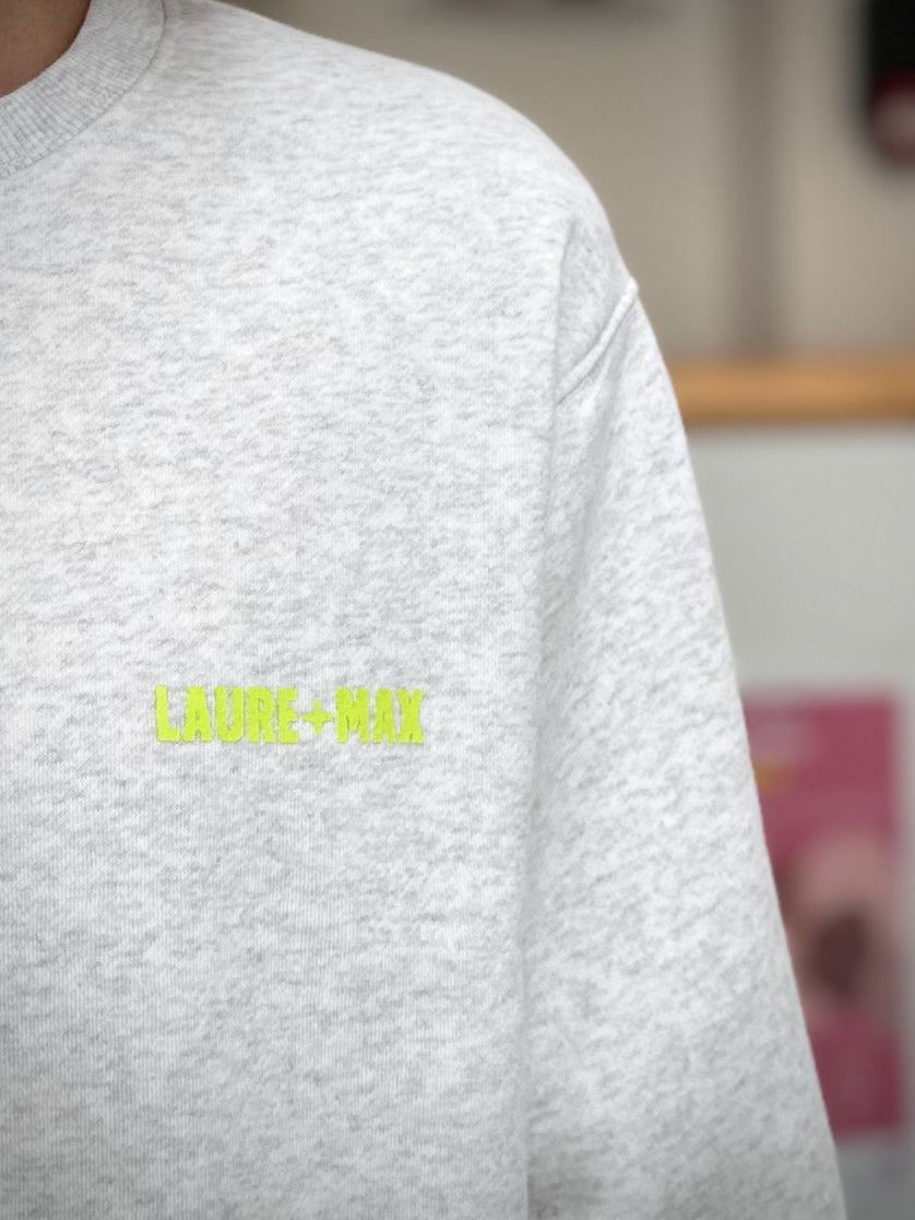 Gros plan sur logo fluo LAURE+MAX sur sweat