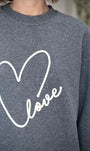 Gros plan sur la broderie “Love” devant