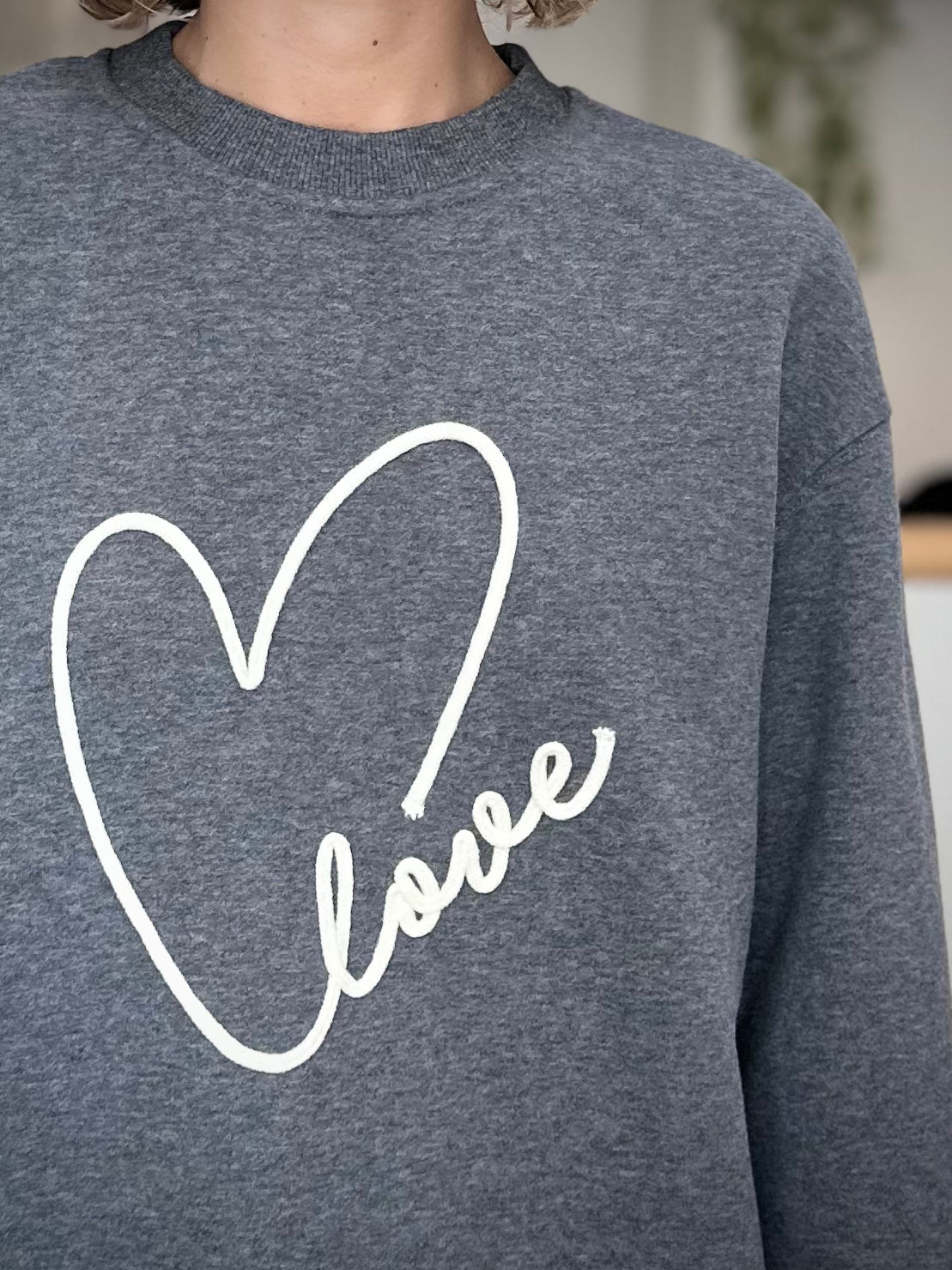 Gros plan sur la broderie “Love” devant