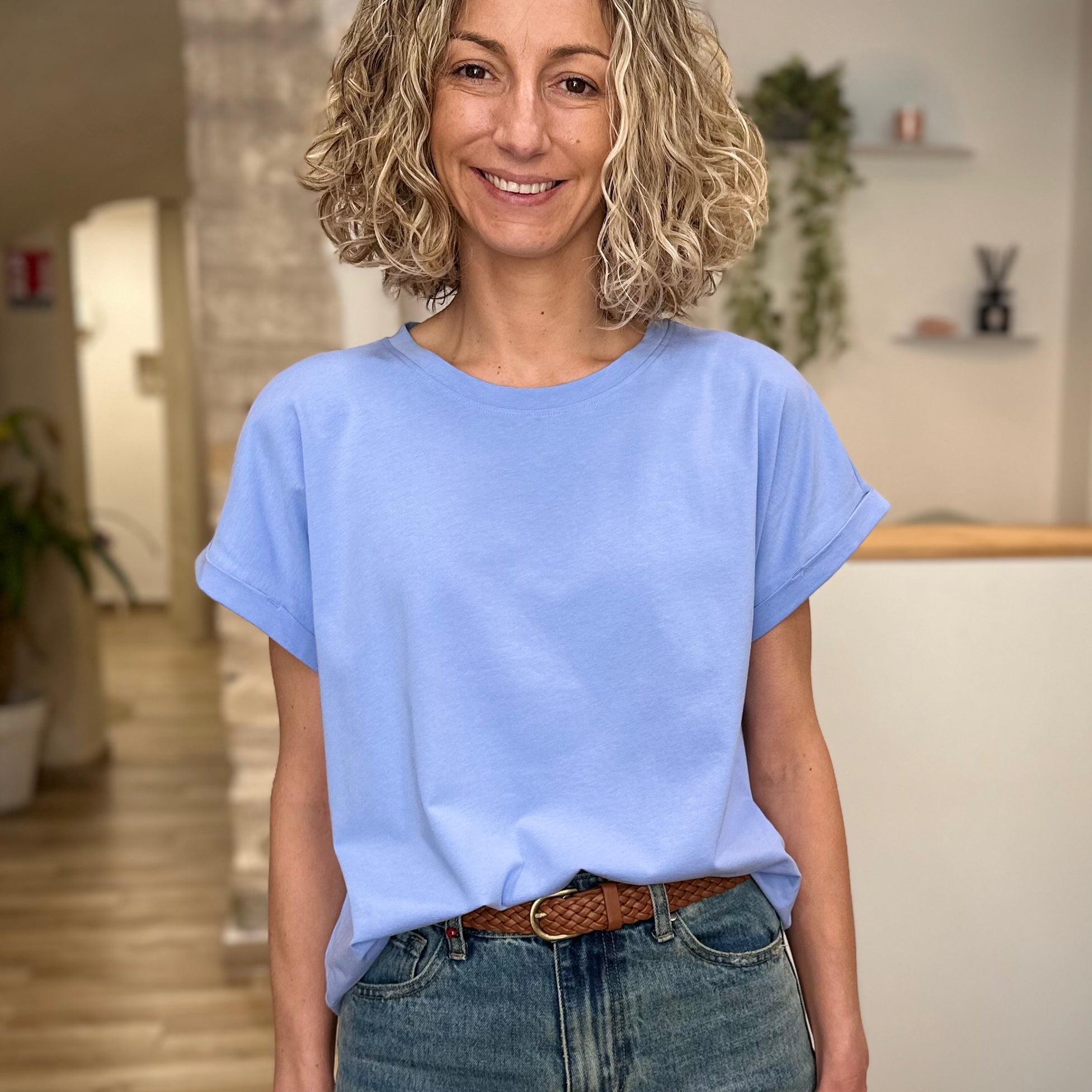 Femme portant un t-shirt bleu clair coupe boxy avec jean 