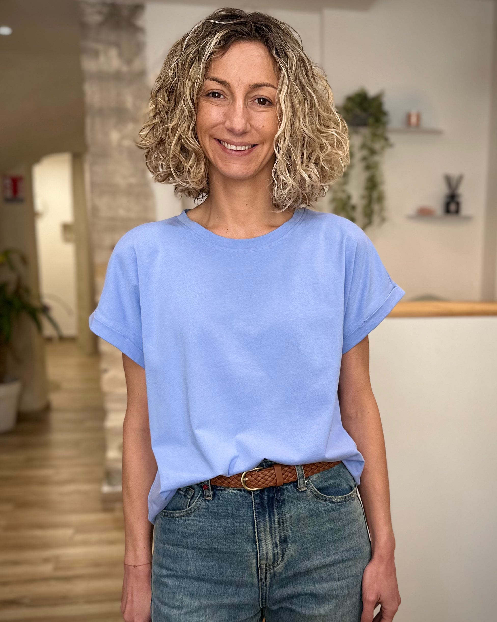 Femme portant un t-shirt bleu clair coupe boxy avec jean 