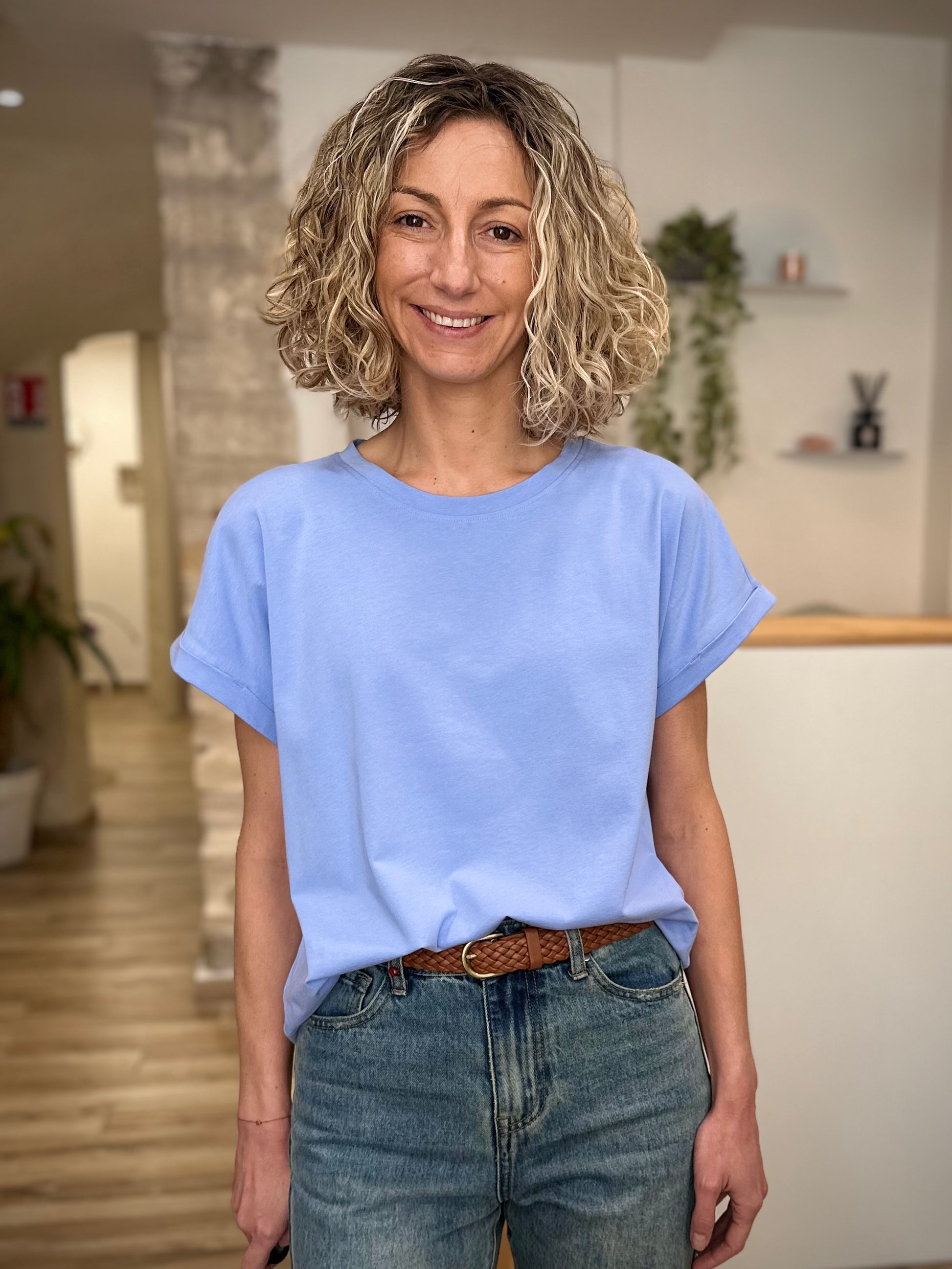 Femme portant un t-shirt bleu clair coupe boxy avec jean 