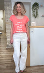 Look estival femme avec tee-shirt corail et pantalon blanc 