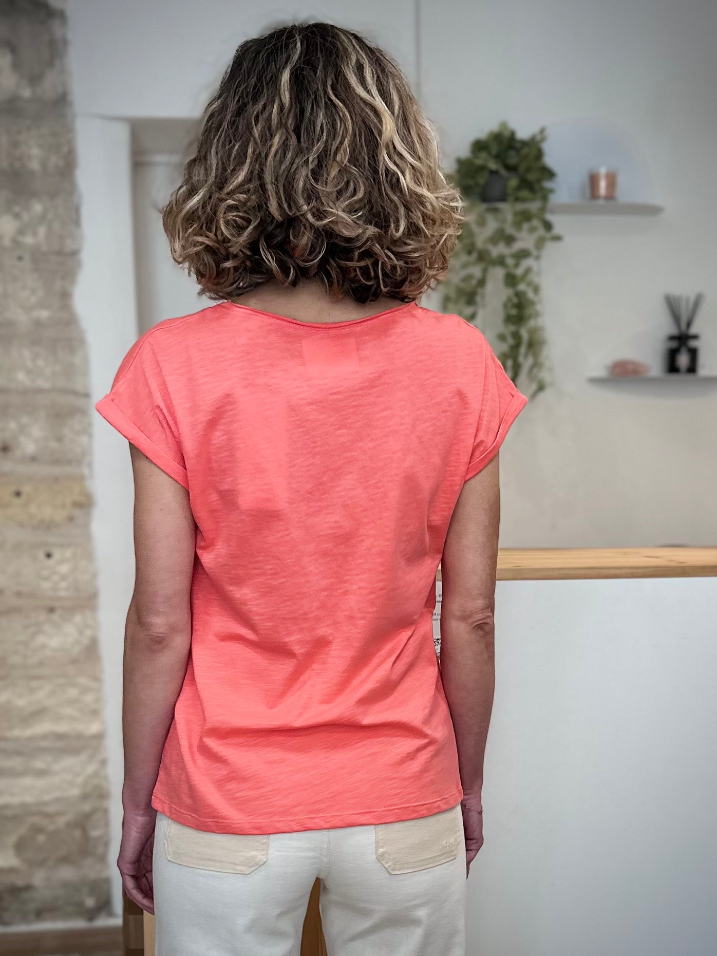 Femme de dos portant un tee-shirt corail manches courtes 