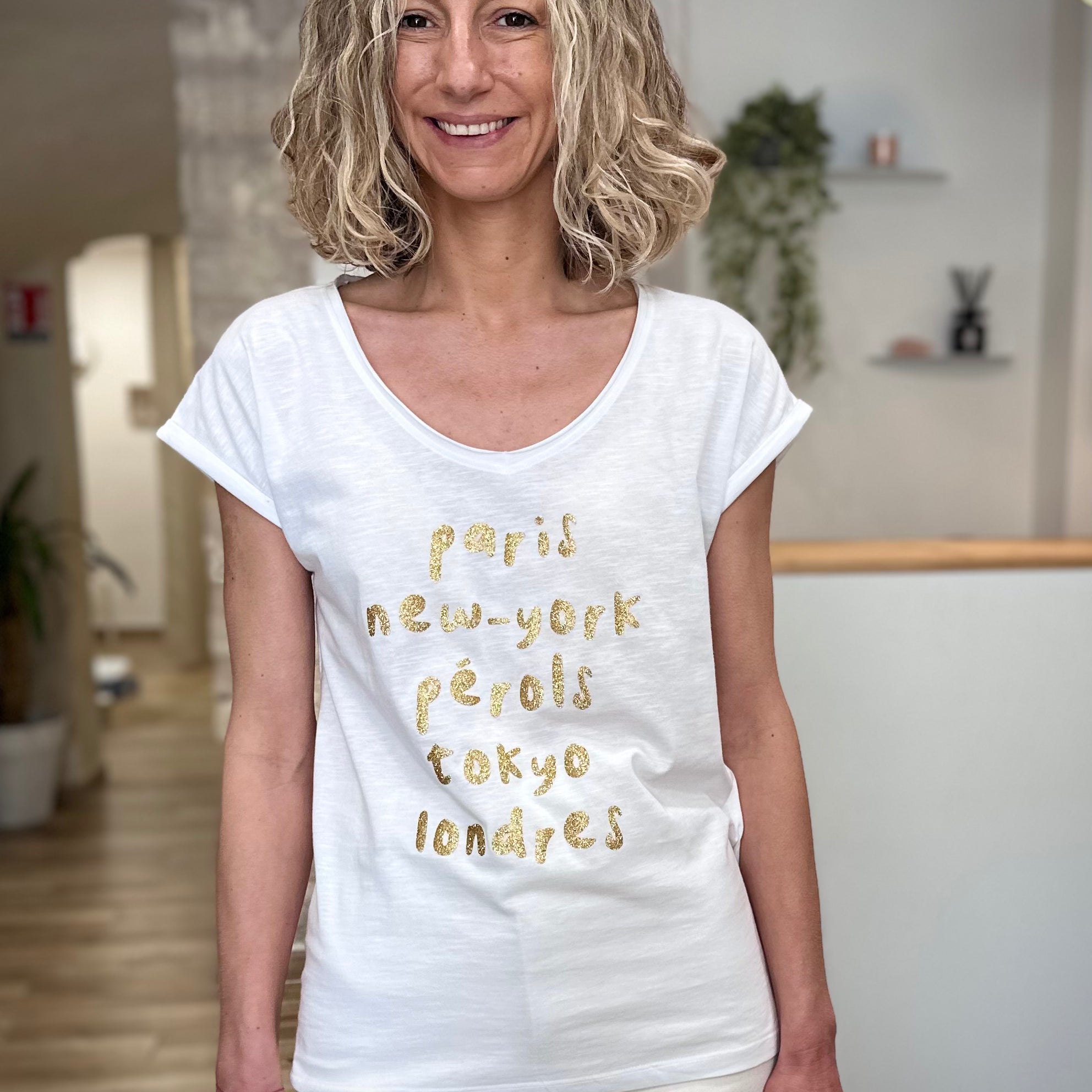 Femme portant un tee-shirt blanc imprimé doré casual chic 