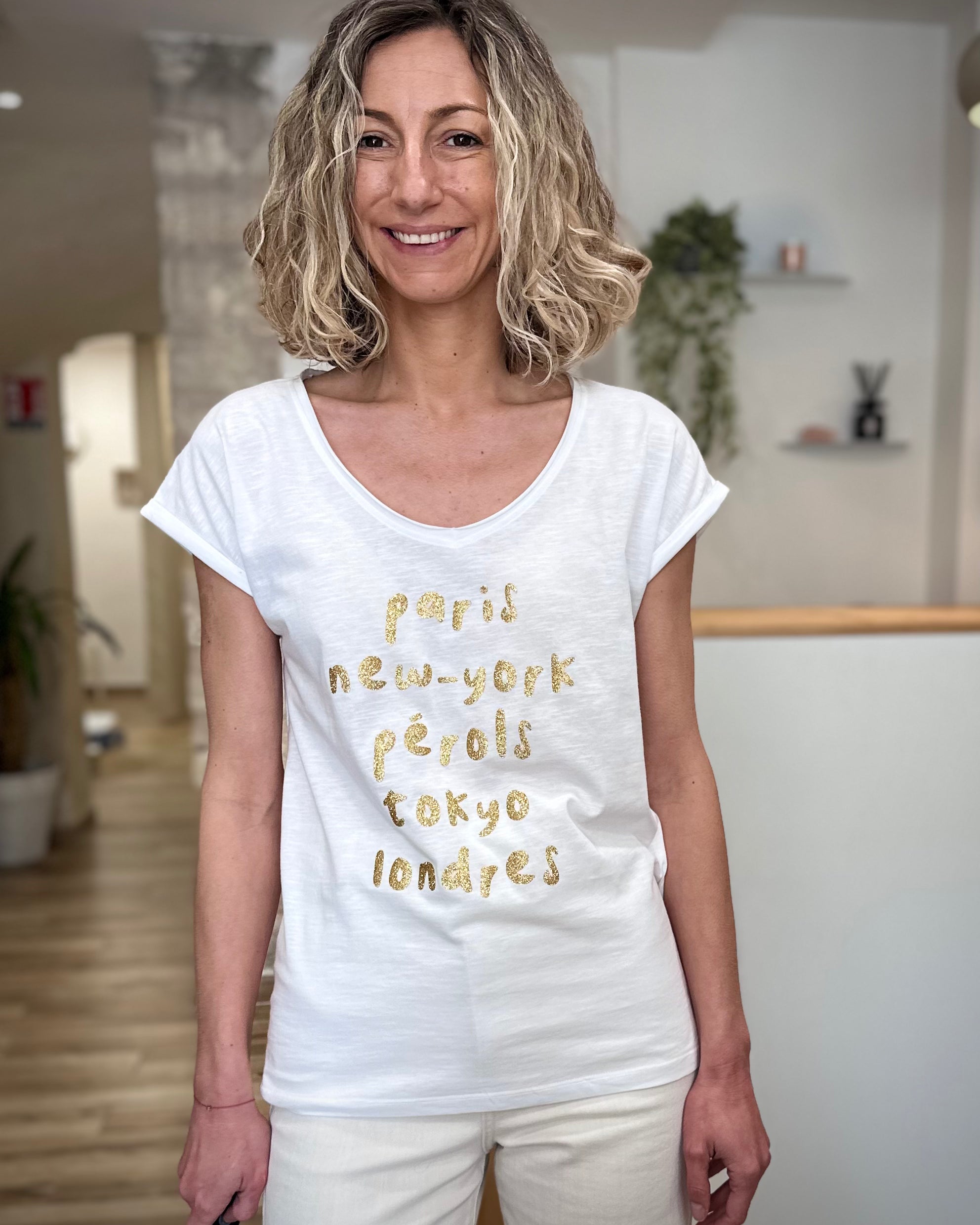 Femme portant un tee-shirt blanc imprimé doré casual chic 