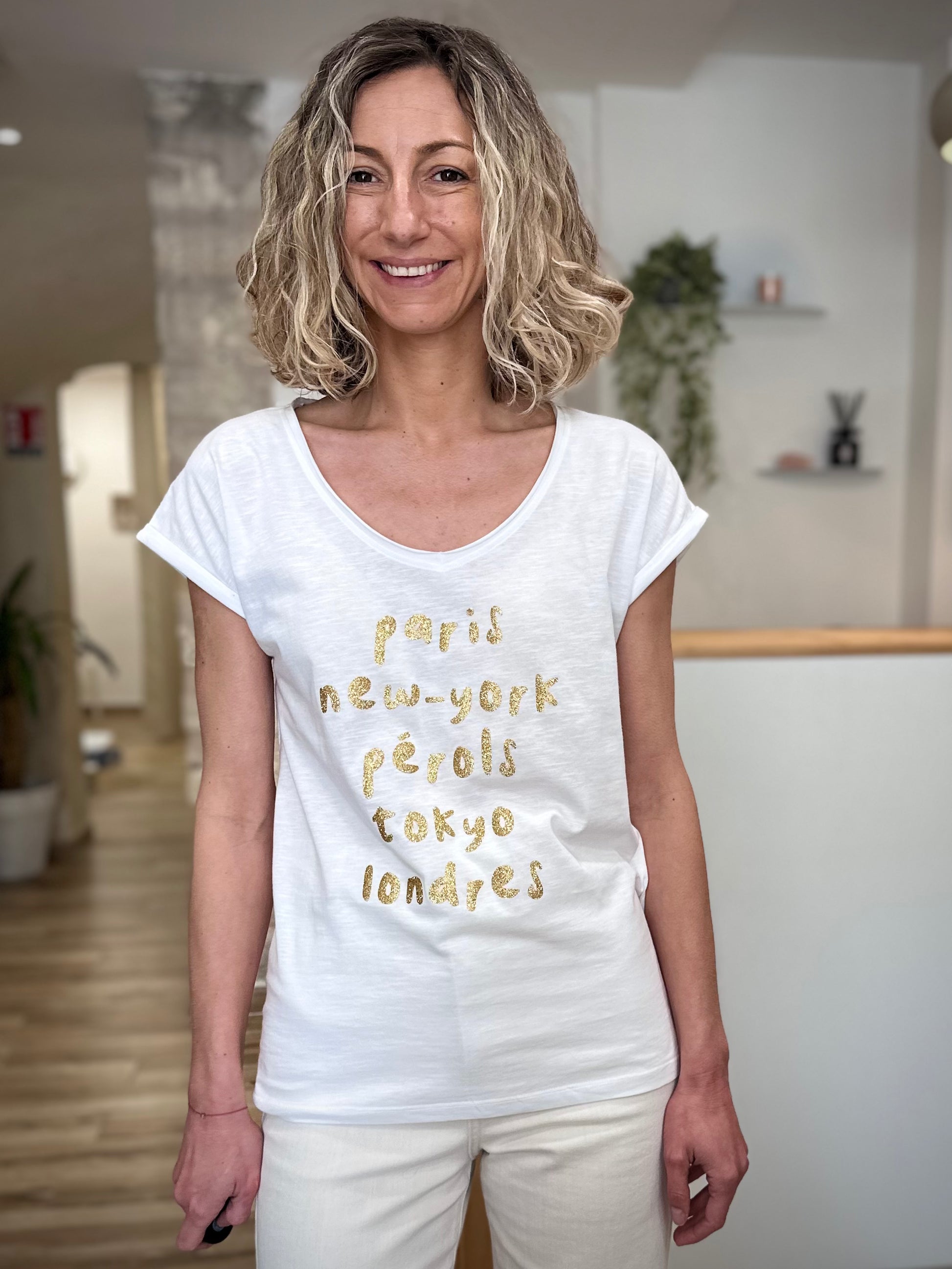 Femme portant un tee-shirt blanc imprimé doré casual chic 