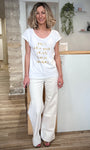 Look estival femme avec tee-shirt blanc et pantalon clair 