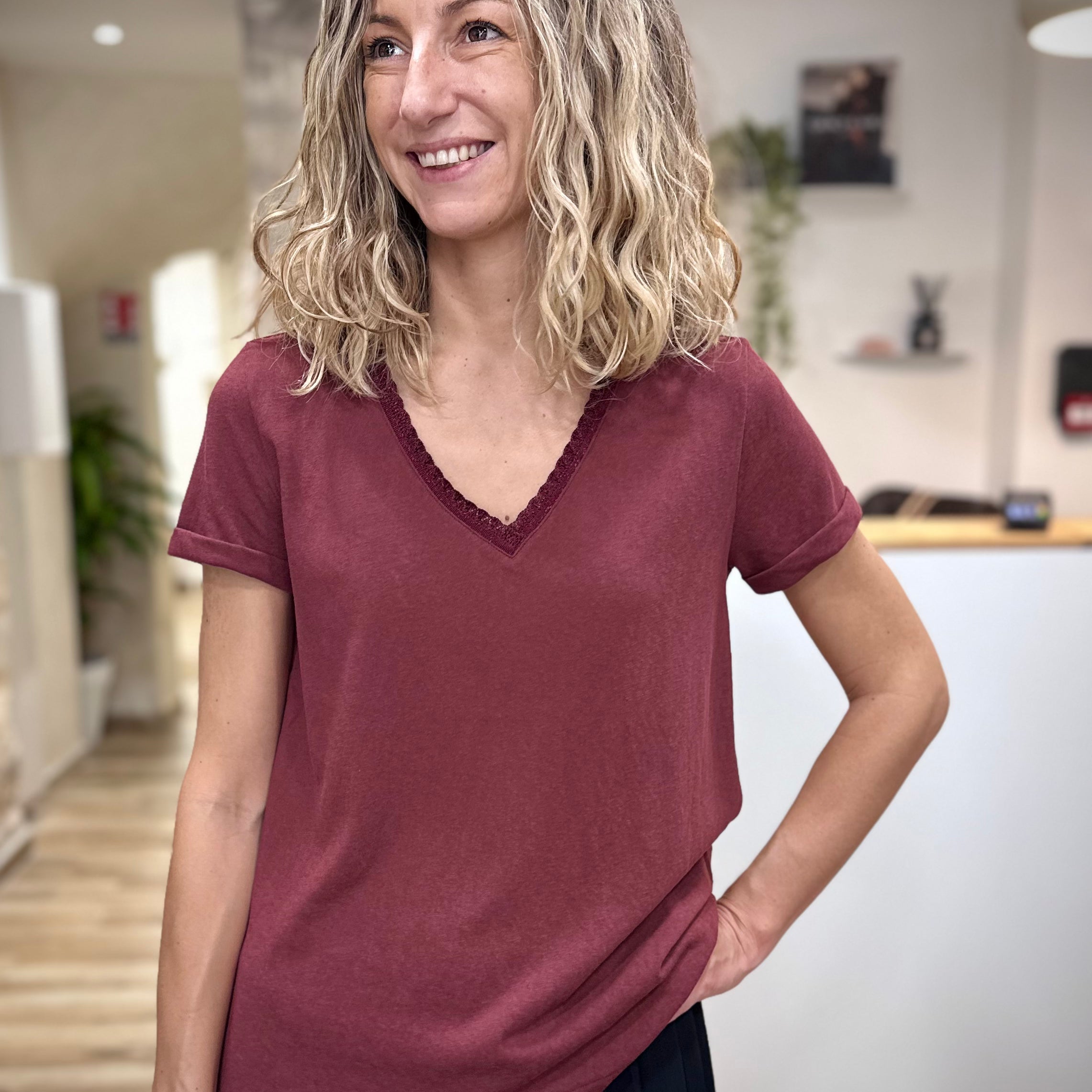 Femme portant un t-shirt bordeaux col V lurex chic