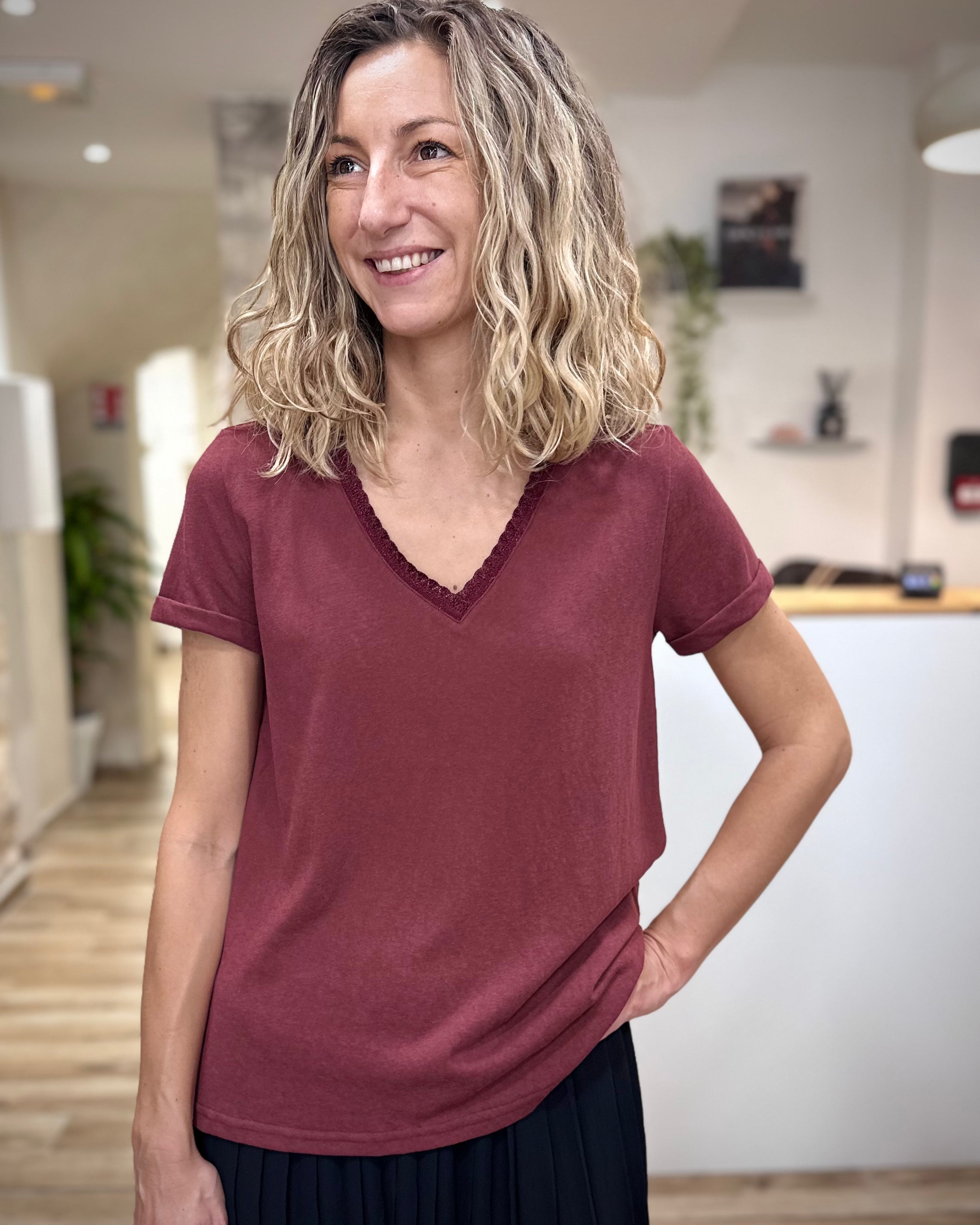 Femme portant un t-shirt bordeaux col V lurex chic